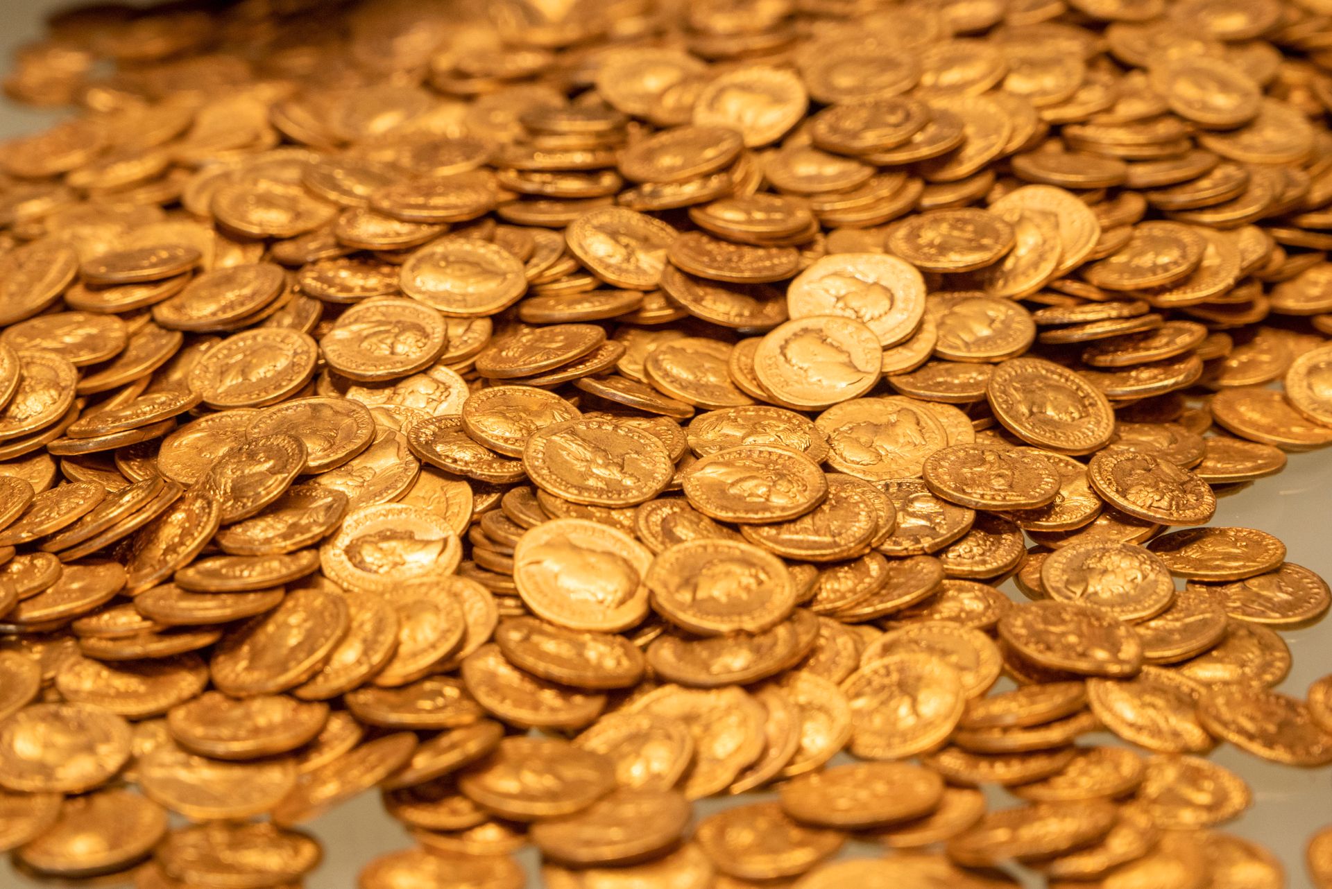 Bildet viser en haug med gamle gullmynter som ligger utover en overflate. 