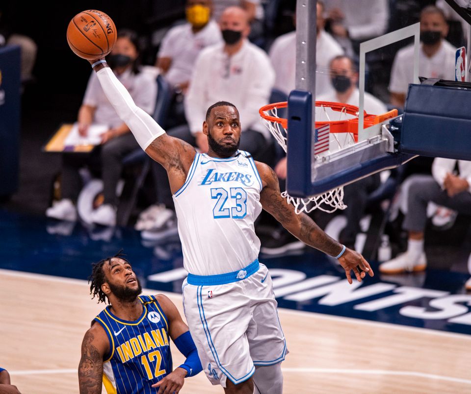 En basketballspiller hoppet høyt og er på vei til å score.