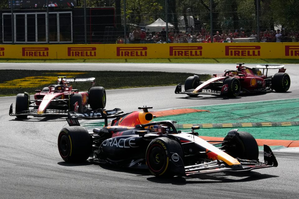 Tre Formel 1-biler kjører etter hverandre i en sving.