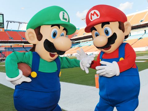 To maskoter på baseball-bane med Luigi og Mario-kostyme