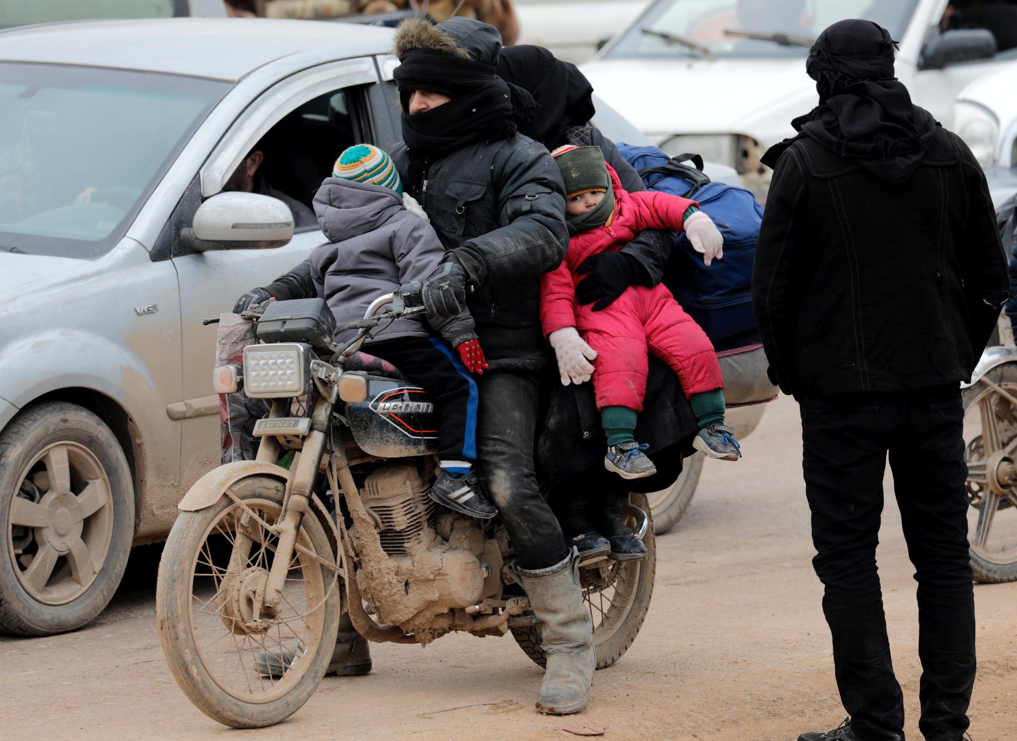 Internt fordrevne syrere rømmer fra krigen på en motorsykkel. Bildet er tatt i Idlib-provinsen den 11. februar.