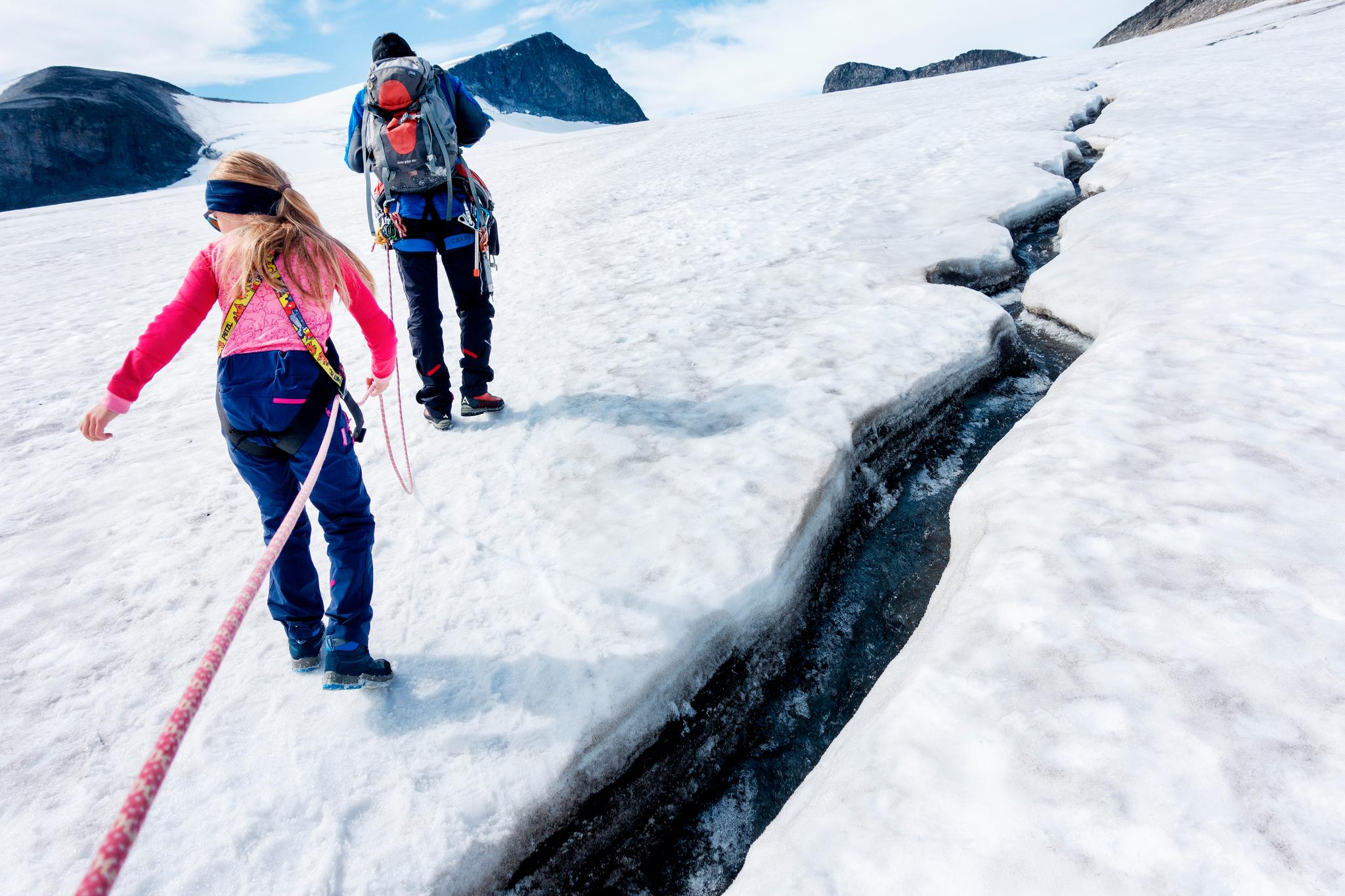 Brefører og turfølge går i tau over isbreen på tur til Galdhøpiggen.