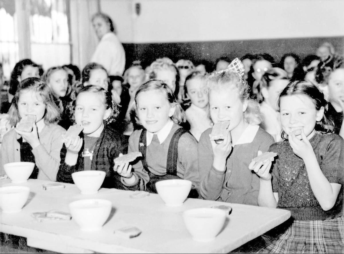 Oslofrokosten var et fast innslag i skoledagen fra 1932 til 1963. Da skulle varme supper og vellinger erstattes med brødmat og melk. Disse skolejentene koser seg med brødskiver på 1950-tallet.
