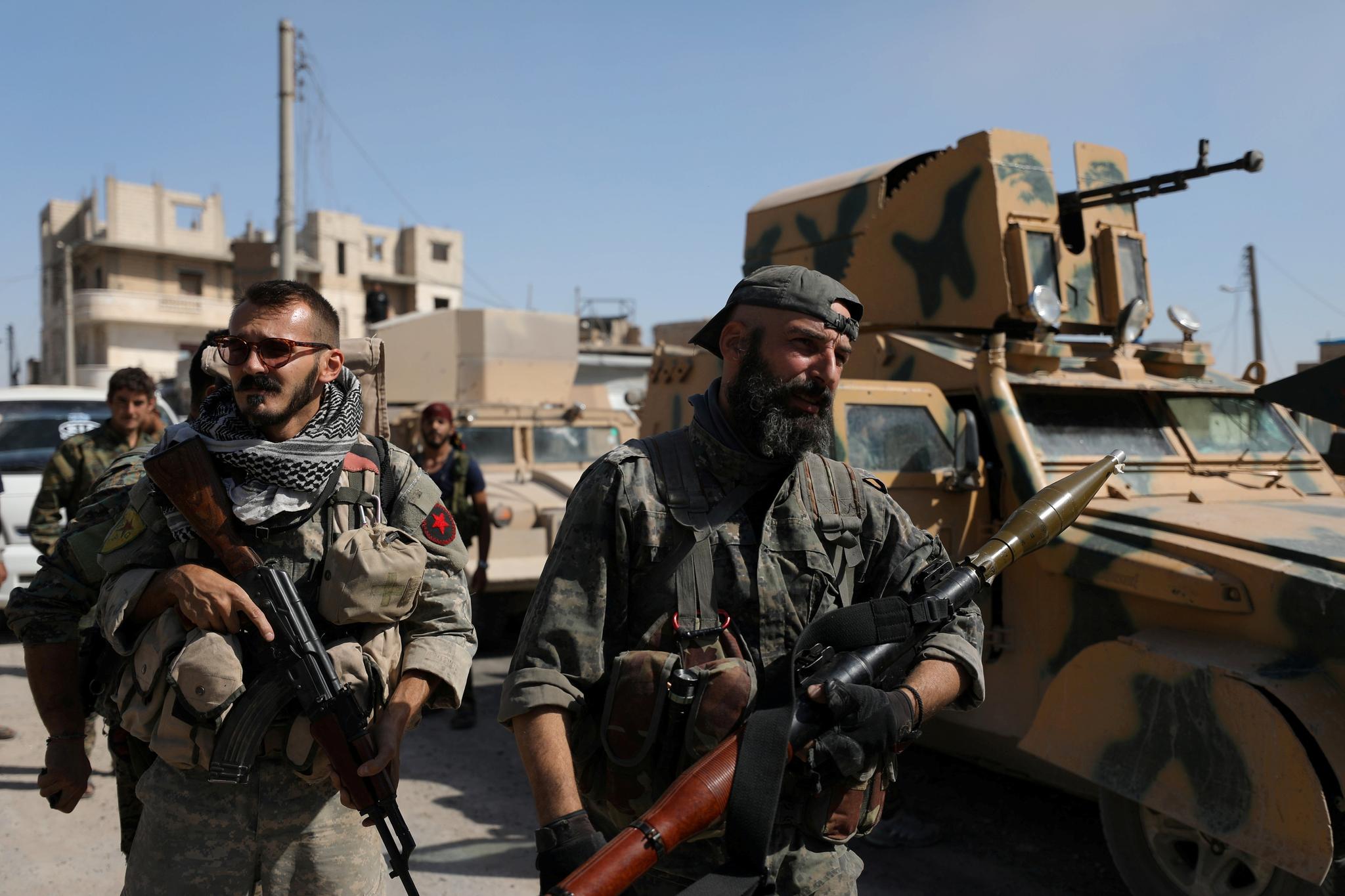  Syrian Democratic Forces (SDF) Bærer våpnene ved siden av et militært kjøretøy. Her i Raqqa, Syria. 