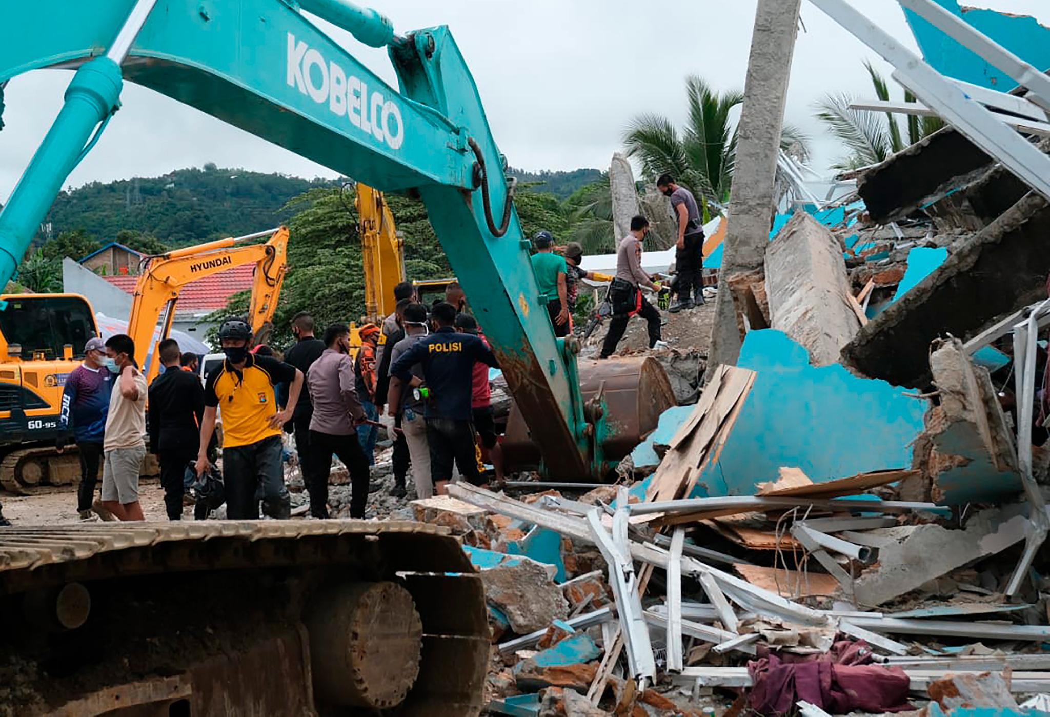 Letemannskaper søker etter overlevende i en sammenrast bygning i Mamuju på Sulawesi i Indonesia etter at et jordskjelv ødela hus og bygninger og førte til flere store jordskred rett etter midnatt. 