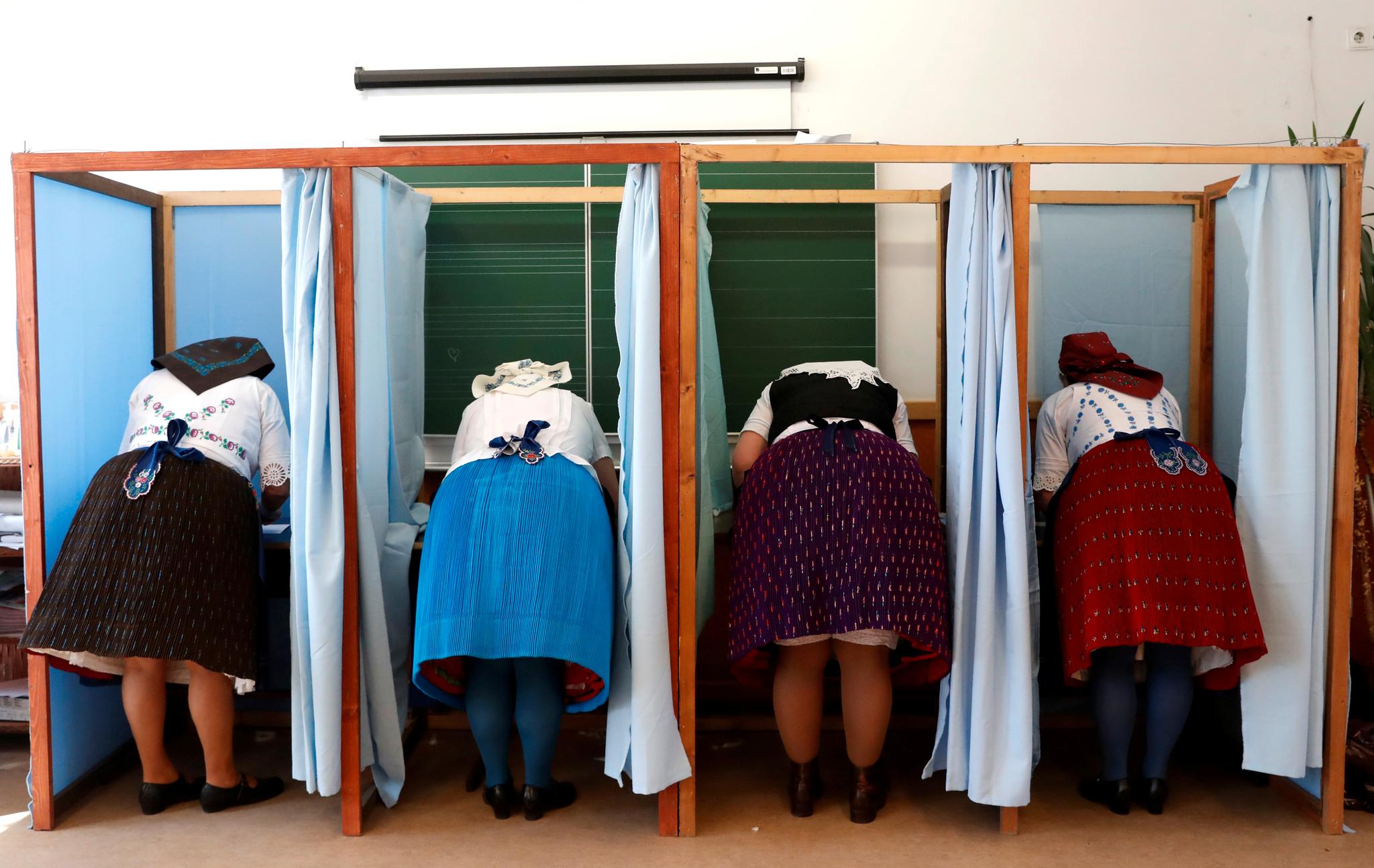 Kvinner i tradisjonelle ungarske drakter avla stemme samtidig i et valglokale i Veresegyhaz søndag formiddag. 