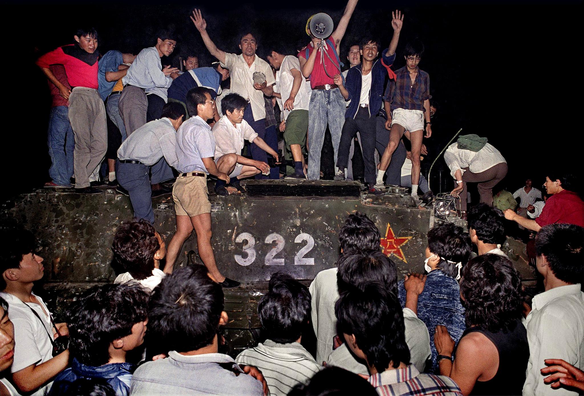 Kveld 3. juni 1989: Demonstranter okkuperer et militært kjøretøy i området rundt Den himmelske freds plass. Vognen kjørte i forkant gjennom sperringene som mengden hadde satt opp for å hindre de militære kjøretøyene.