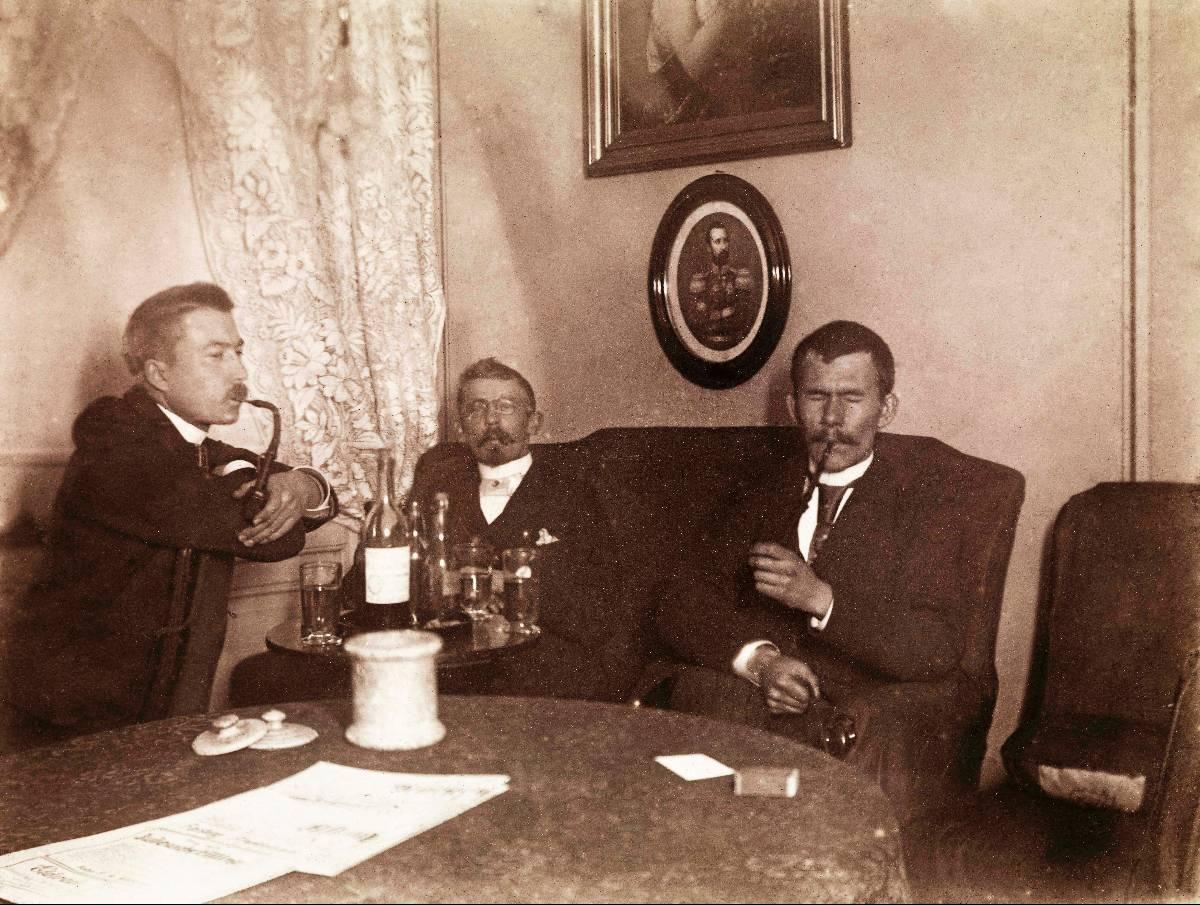 Piperøyking og noe godt i glasset var selvsagte ingredienser i disse herrenes lørdagskveld. Bildet er tatt i Wessels gate 15 i 1891.