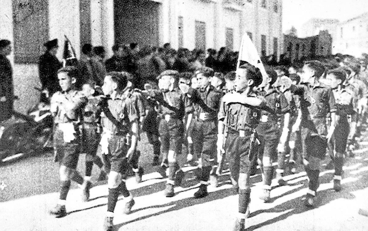 Barnehjemsbarn iført uniform fra Auxilio Social – Sosialhjelpen – marsjerer gjennom Madrids gater på begynnelsen av 1940-tallet. 