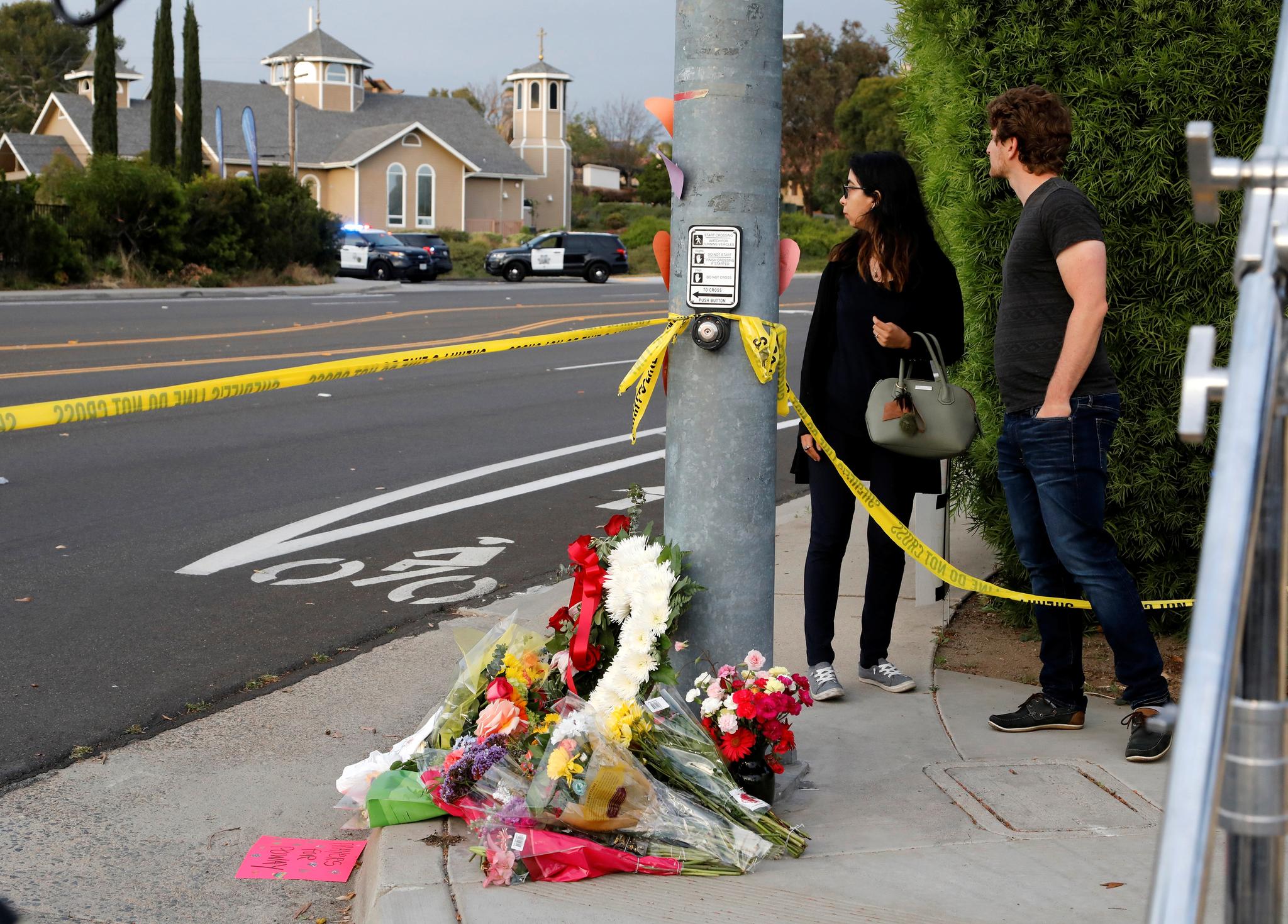 Folk har lagt ned blomster ved et gatelys like ved synagogen som ble angrepet. 