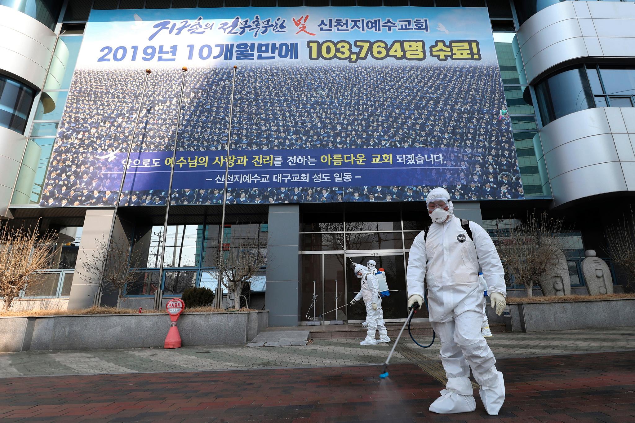 Arbeidere sprayer med desinfiserende midler utenfor lokalene til Shincheonji-kirken i Daegu i Sør-Korea den 20. februar.