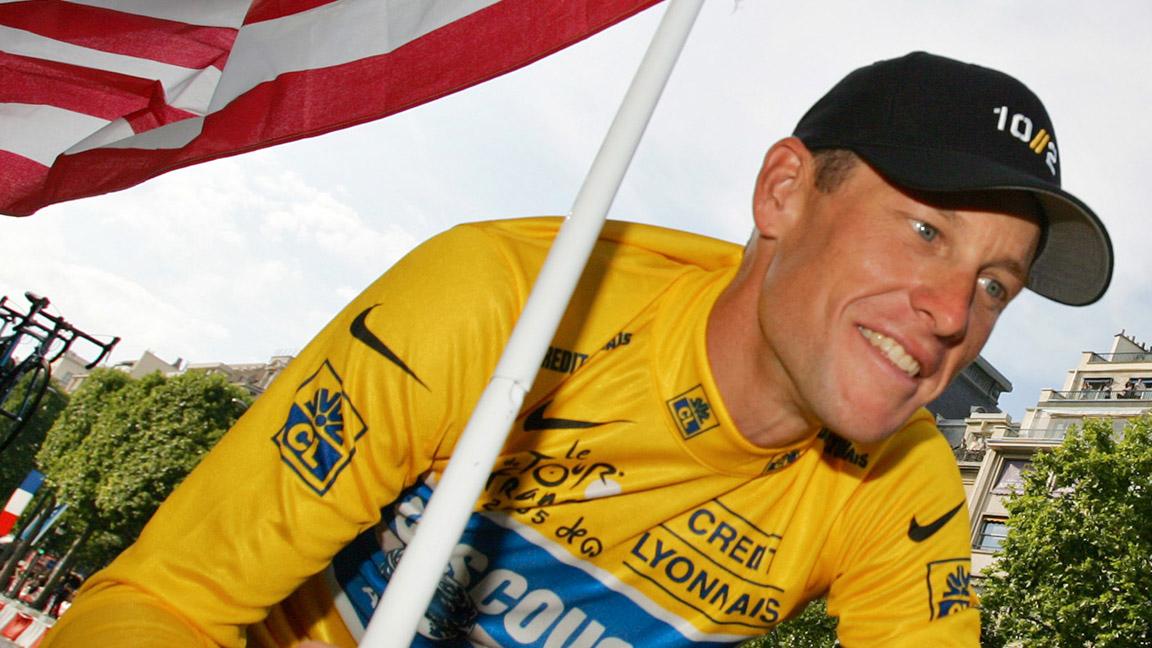 FILE - In this July 24, 2005  file photo, Lance Armstrong, of Austin, Texas, carries the United States flag and wears a jersey with Nike logos during a victory parade on the Champs Elysees avenue in Paris,  after winning his seventh straight Tour de France cycling race. Armstrong stepped down as chairman of his Livestrong cancer-fighting charity and Nike severed ties with him as fallout from the doping scandal swirling around the famed cyclist escalated Wednesday, Oct. 17, 2012. (AP Photo/Peter Dejong, File)