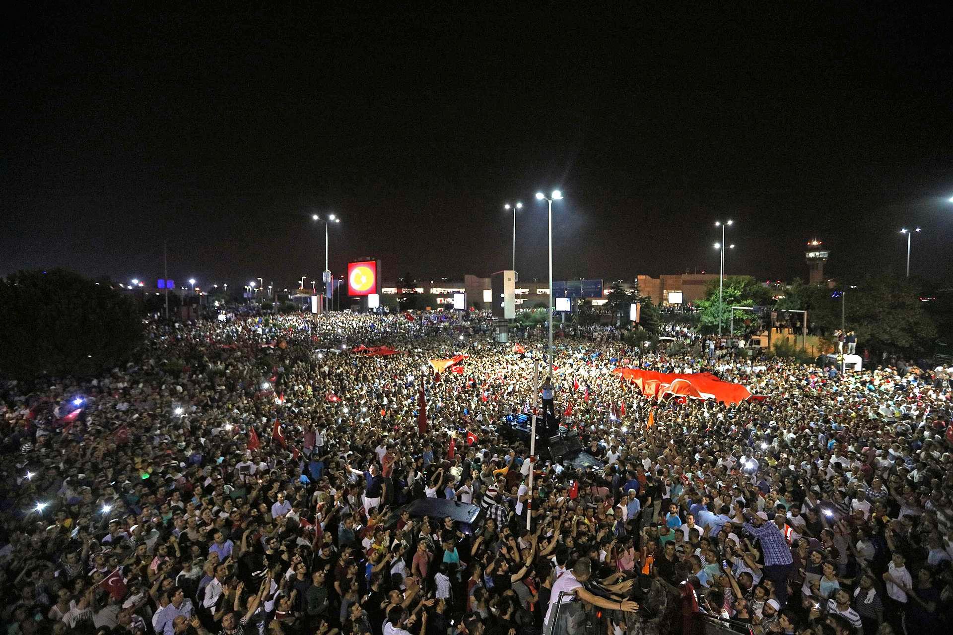 Fra ukjent sted maner president Erdogan folk til å trekke ut i gatene. Han blir hørt. Enorme menneskemengder samler seg i protest ved Atatürk-flyplassen i Istanbul.