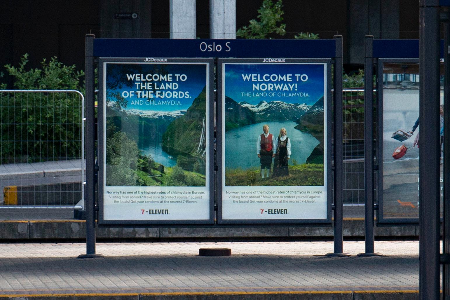 «Velkommen til Norge! Klamydia-landet!» Kioskkjeden 7-Eleven ønsker reisende velkommen til Oslo S med sine nye reklameplakater som inneholder Norgesreklame – og info om klamydiabeskyttelse. 
