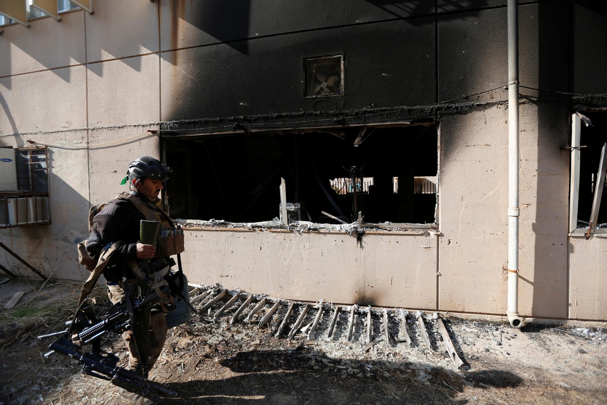 Et medlem av irakske spesialstyrker går forbi en av de ødelagte bygningene til universitetet i Mosul.