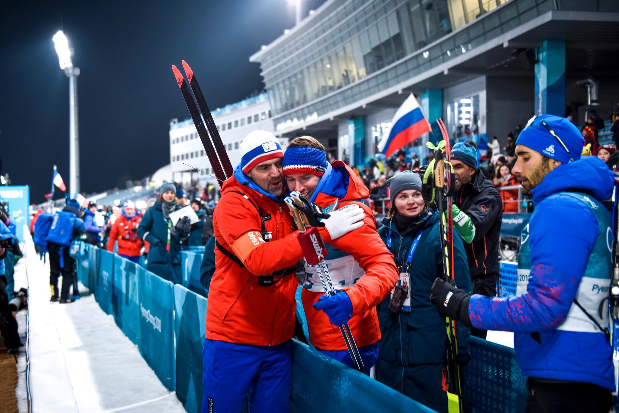 Svendsen får en klem av den norske skiskyttertreneren Siegfired Mazewt. Han var tidligere trener til gullvinner Martin Fourcade som står til høyre her. 