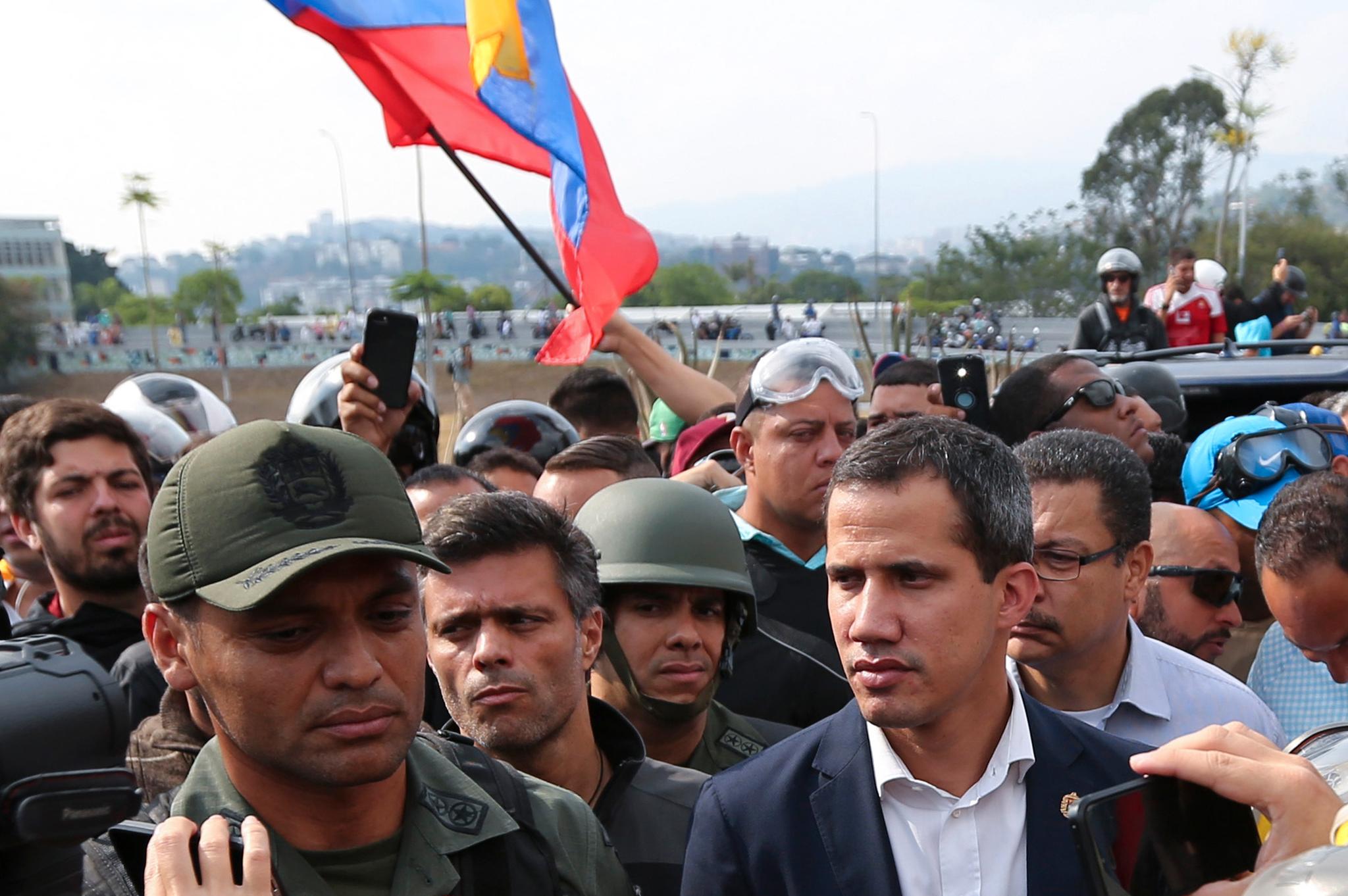 Opposisjonsleder og selvutnevnt midlertidig president Juan Guaidó står her sammen med ikke navngitte soldater og offiserer.