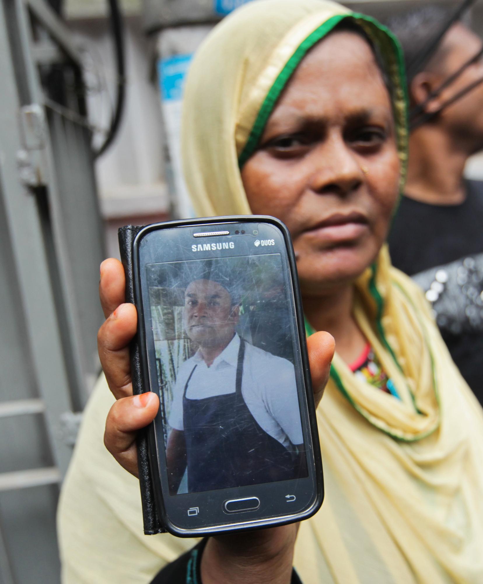 SLEKTNING: Johura Begum viser frem et foto av sin svigerbror Saidul Islam, som jobber på den angrepne restauranten. Islam er savnet.