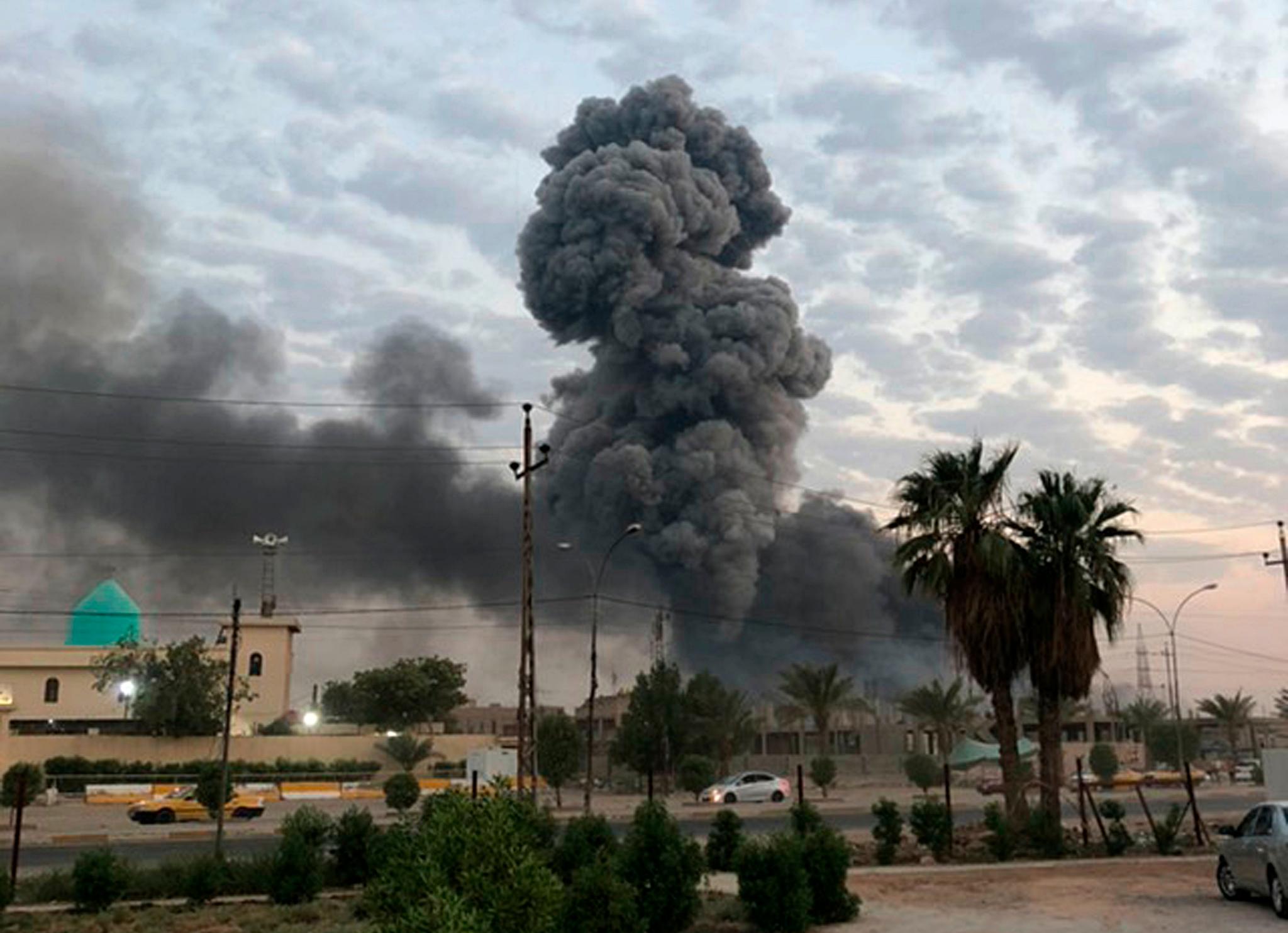 En røyksøyle stiger opp mot himmelen etter en enorm eksplosjon i en militærbase utenfor Bagdad 12. august. En irakisk granskning konkluderte med at basen ble bombet ved hjelp av en drone.