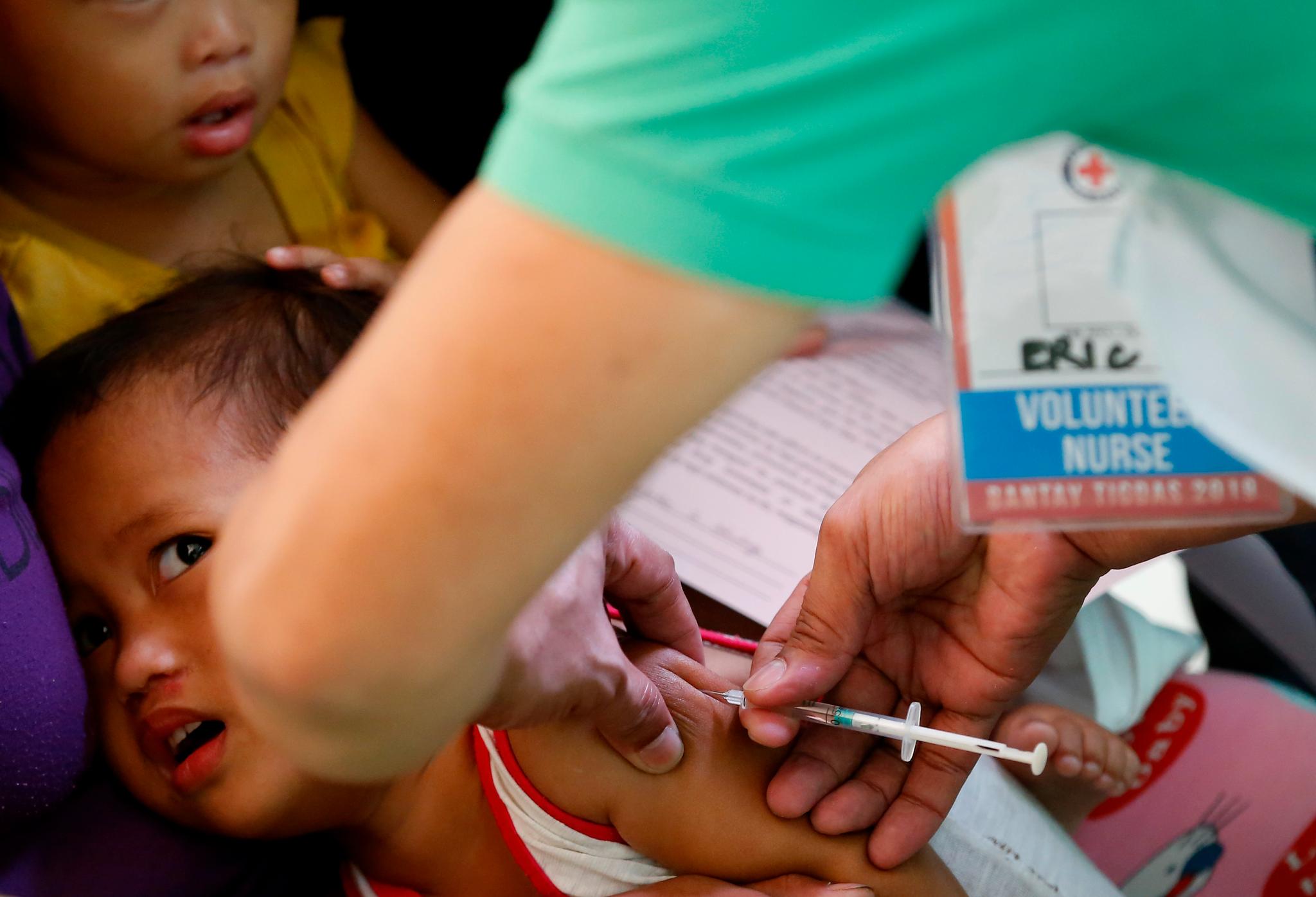 Et barn på Filippinene får vaksine mot meslinger. Foto: Bullit Marquez / AP / NTB scanpix