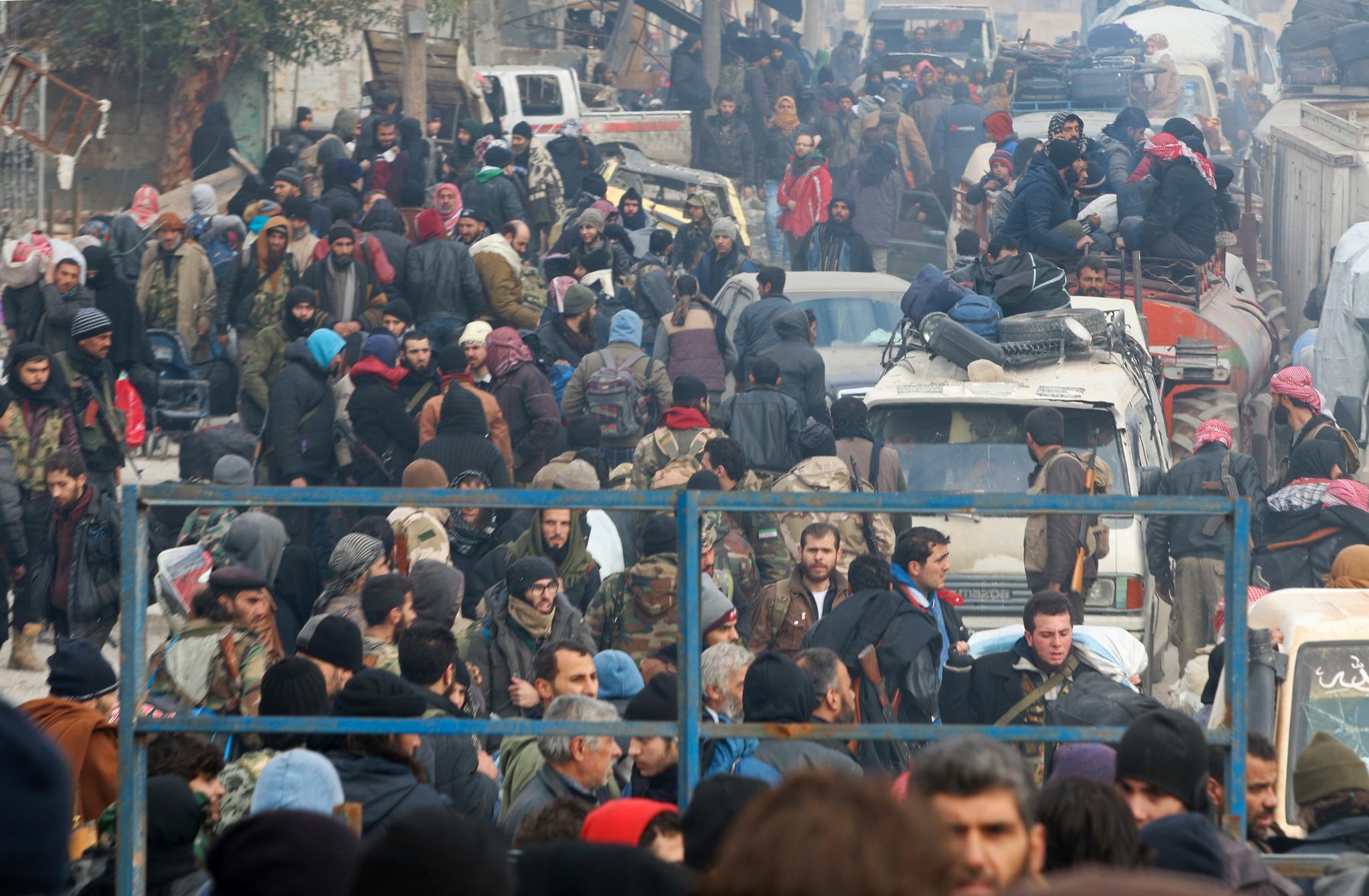 Opprørere og sivile venter på å bli evakuert fra Øst-Aleppo. Bildet er fra fredag.