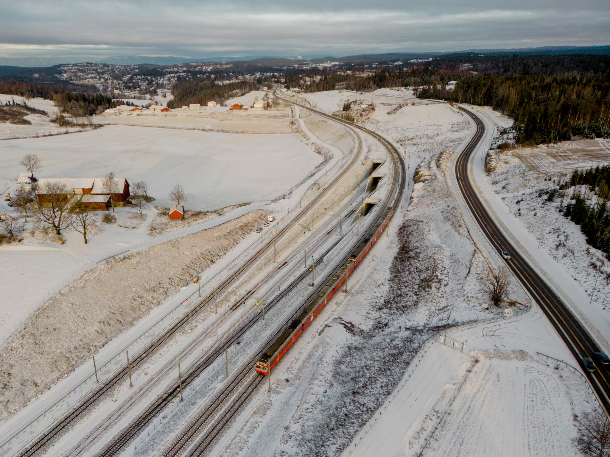 Et tog kjører på Østfoldbanen over inngangene til Blixtunnelen og Roåstunnelen fra Ski i retning mot Oslo S. Follobanen ble åpnet 12. desember, men ble stengt åtte dager senere.