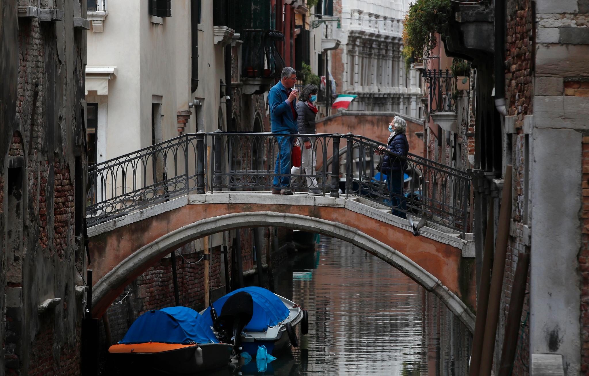 Noen få mennesker er ute og går i de stort sett folketomme smugene i Venezia 13. mai. Nå har landet åpnet opp igjen, men når grensene fortsatt er stengt for utlendinger, gjør det liten forskjell for Venezia. 
