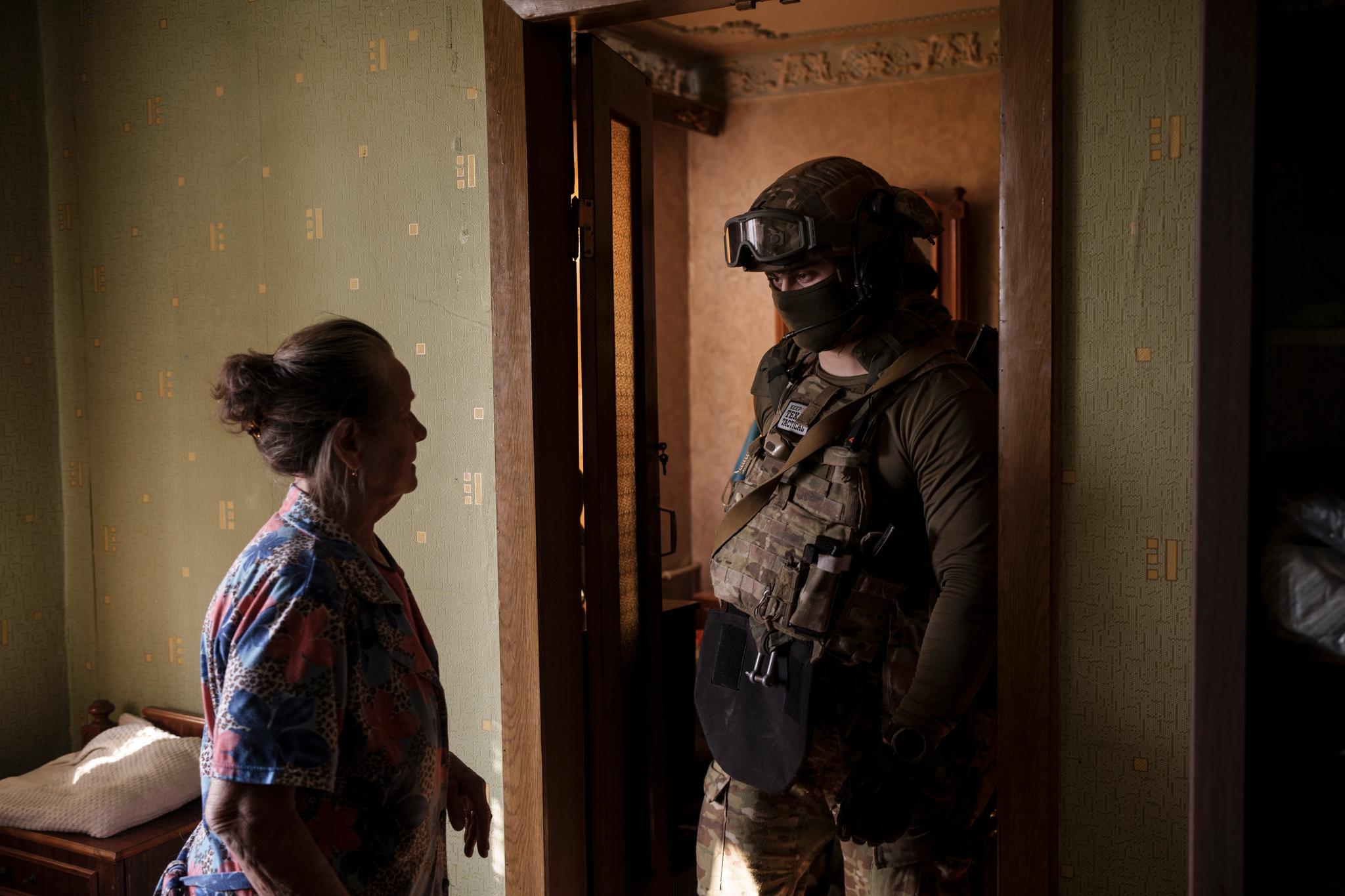 En offiser fra den ukrainske sikkerhetstjenesten snakker med en kvinne under jakten på folk som har samarbeidet med russiske okkupanter. Bildet er tatt i Kharkiv 14. april i fjor.