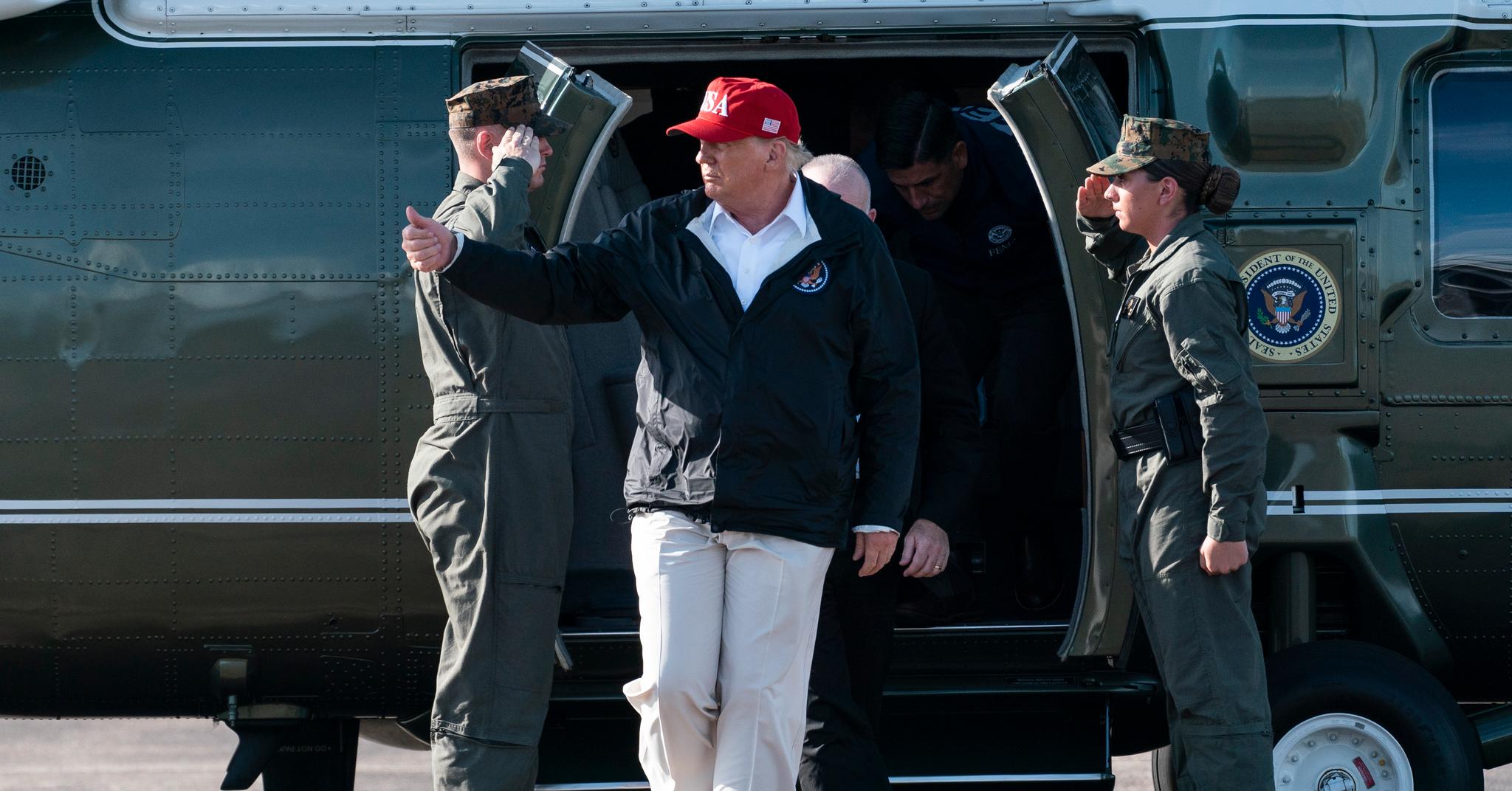 President Donald Trump mottar honnør fra to soldater idet han går ut av helikopteret sitt i Louisiana.