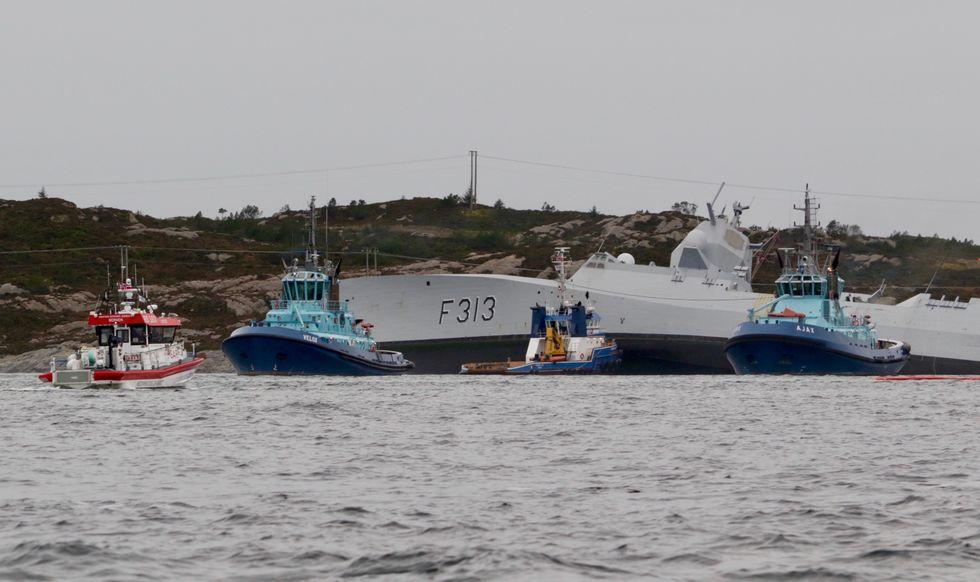 Fregatten «Helge Ingstad» er nå kjørt på grunn i skjærgården for å hindre at den skal synke. Skipet tar inn store mengder gjennom flengen som er synlig på styrbord side. 