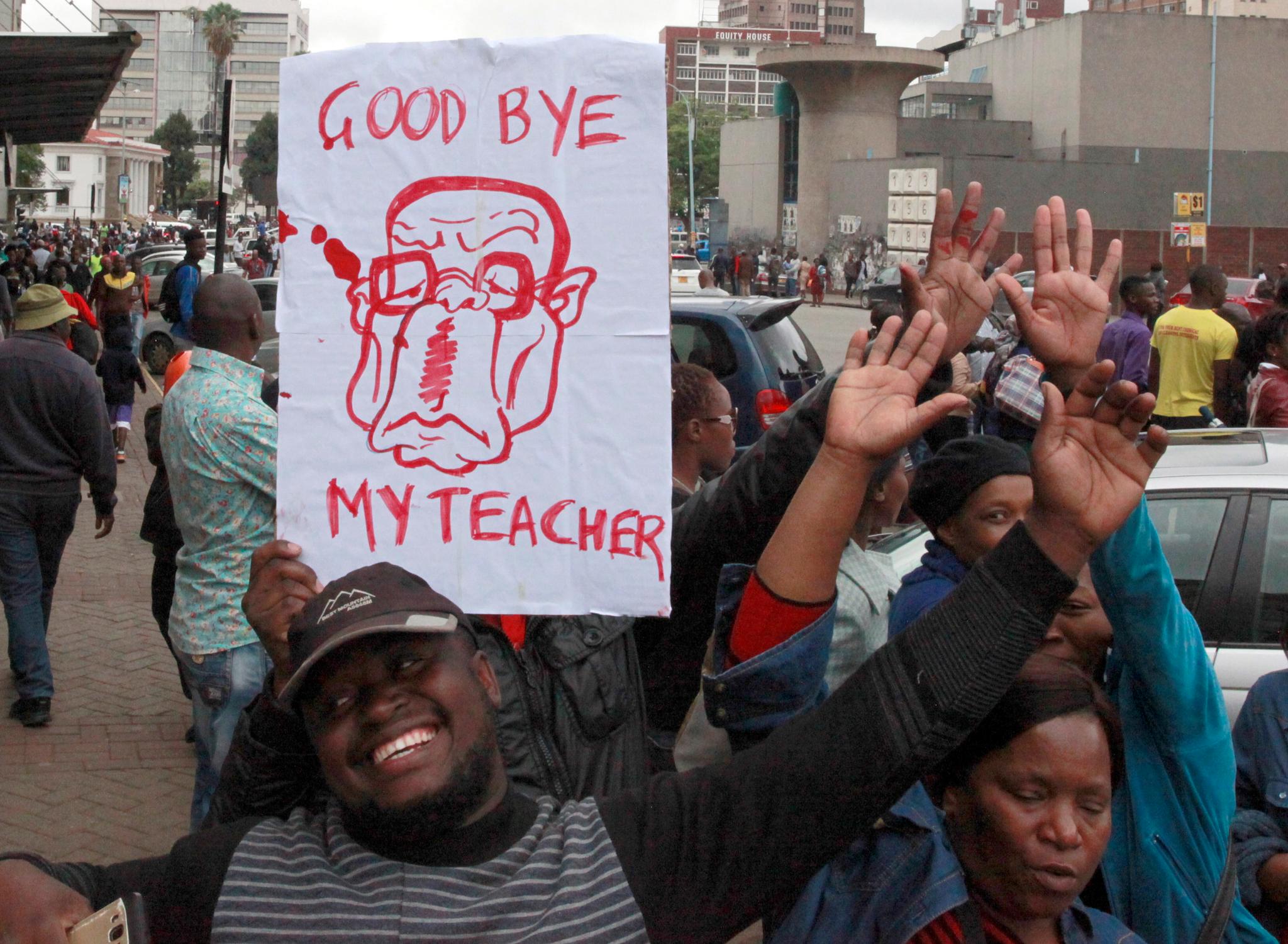 En slem karikatur av den tidligere læreren Robert Mugabe holdes frem av demonstranter i Harare. Nettopp undervisning er imidlertid en av den nå så forhatte presidentens udiskutable store suksesser: Nesten 90 prosent av Zimbabwerne kan lese og skrive. 