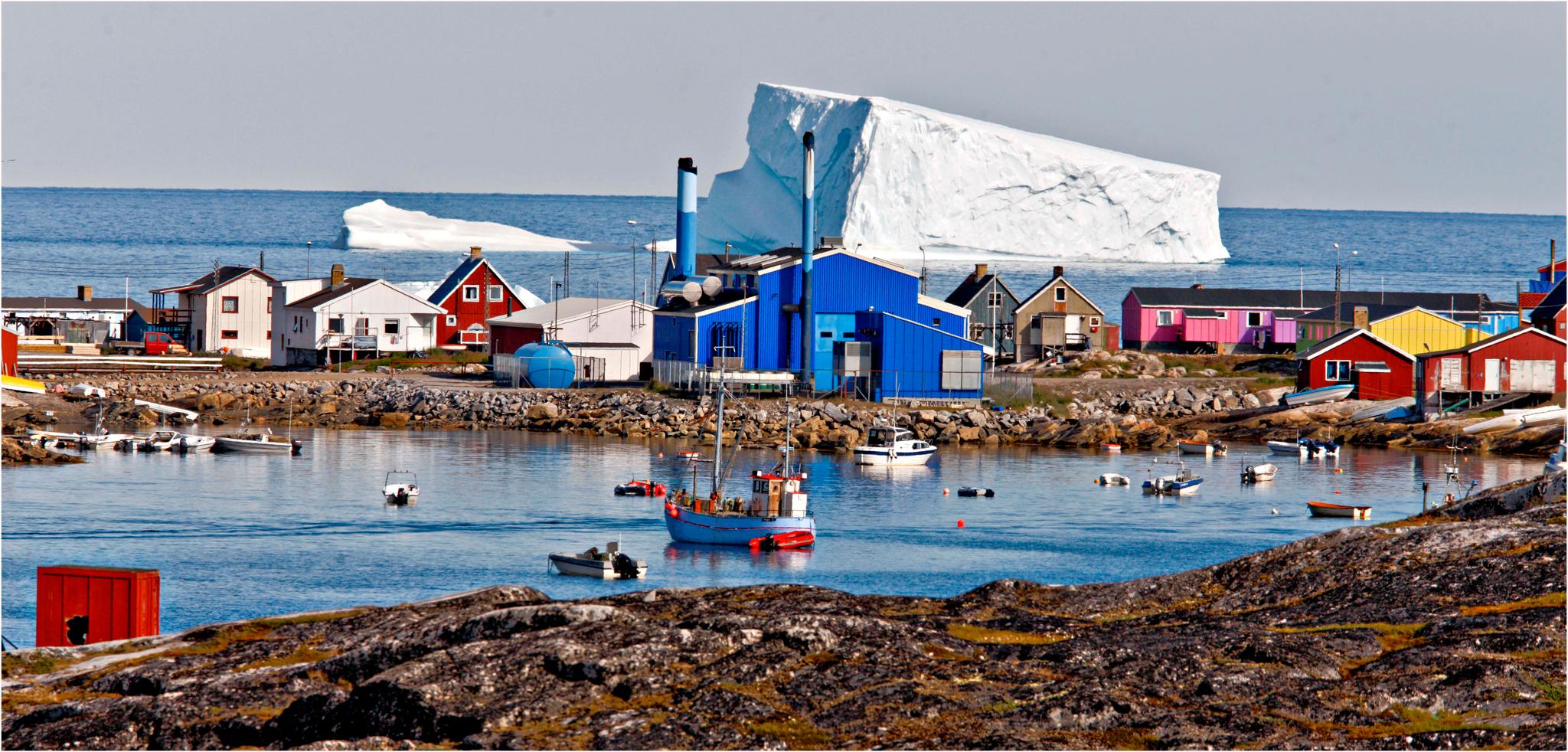 I den lille byen Qeqertarsuaq på Grønland flyter enorme isfjell fra breene forbi.
