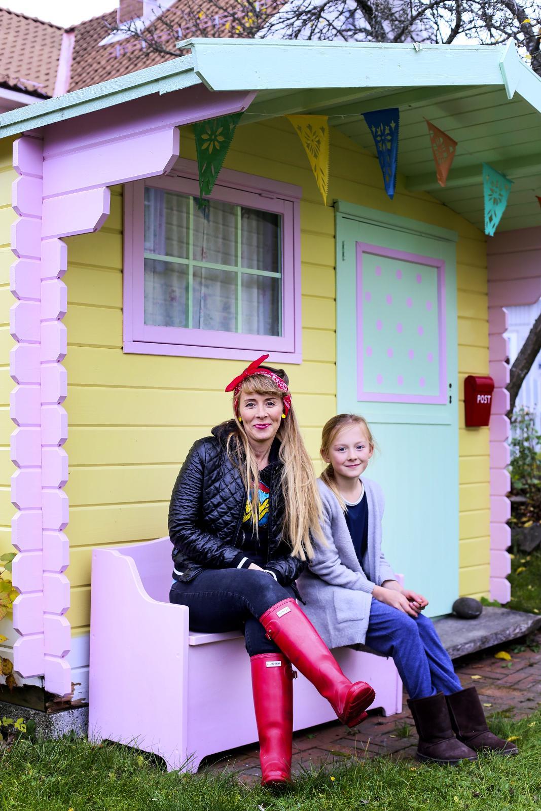 MINIHUS: Dukkestuen er også rikt dekorert i pastell-farger. Her sitter Kate-Alice Mandal-Hergot og Sofie.