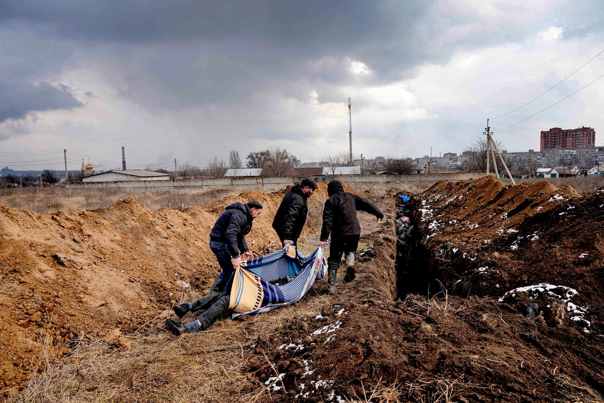 Døde sivile blir lagt i en massegrav i Mariupol 