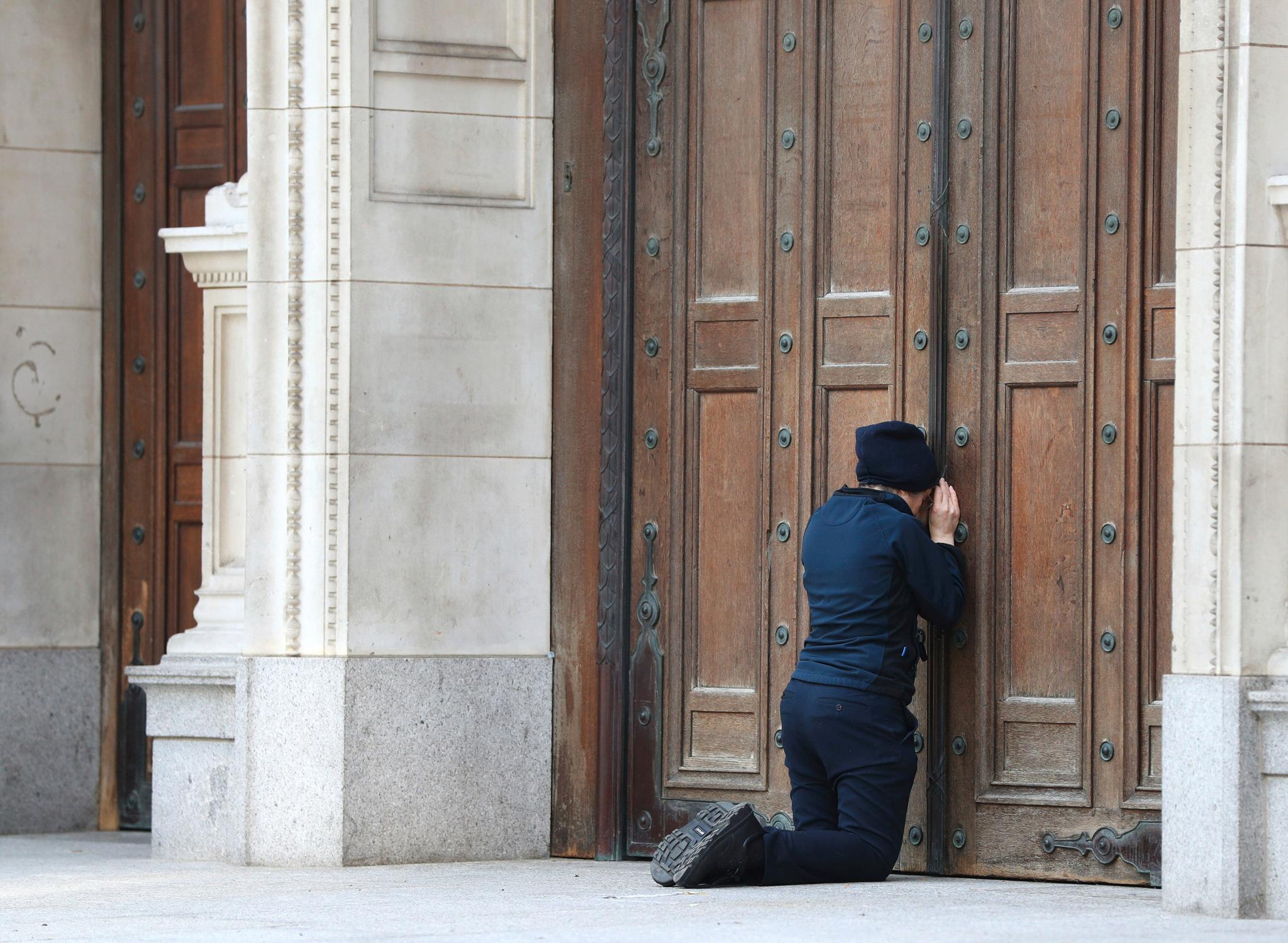 En kvinne ber utenfor de stengte dørene til Westminster Cathedral i London første påskedag. 