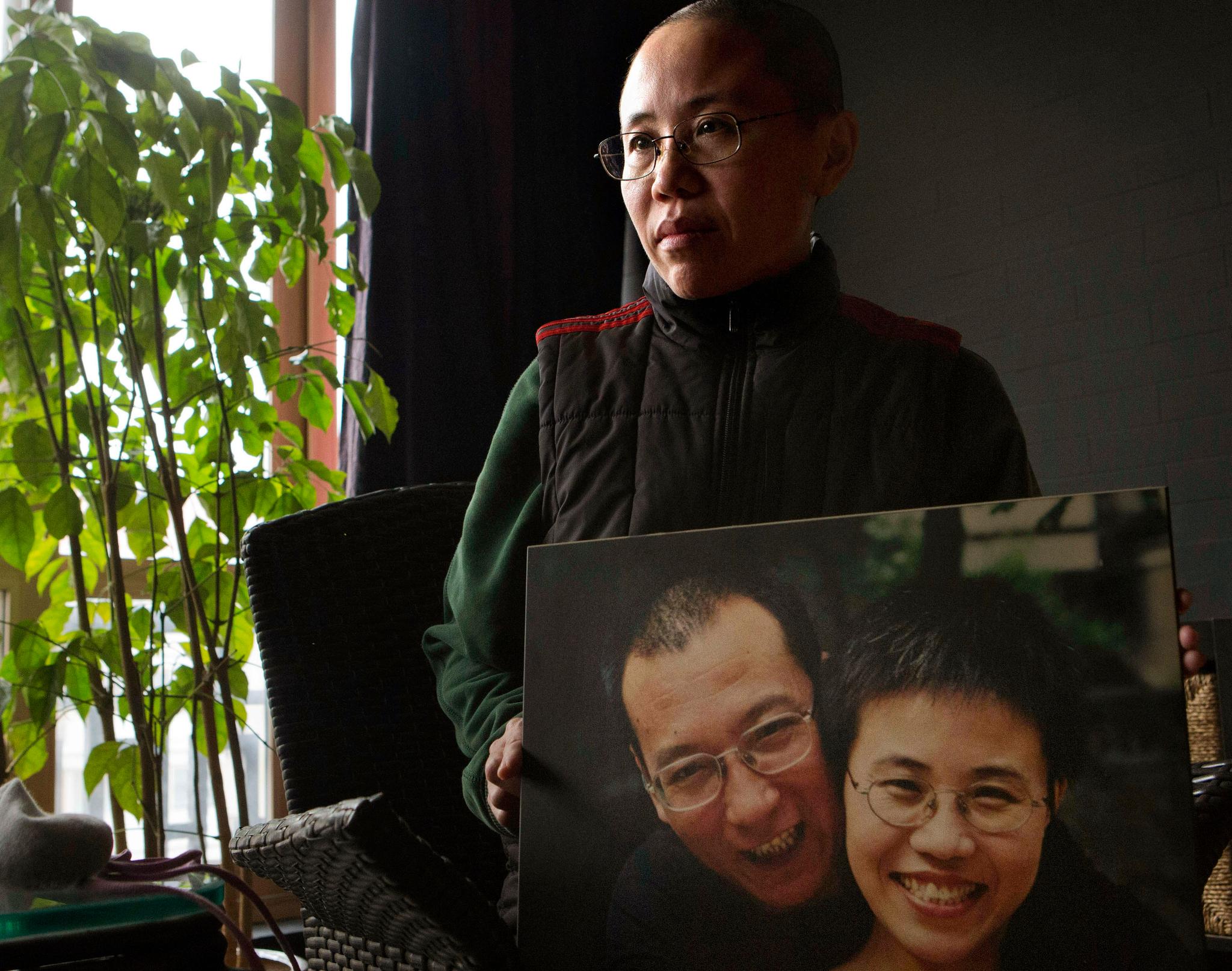 Dette bildet fra 2012 viser Liu Xiaobos kone, Liu Xia, med et bilde av seg og sin fengslede mann. USA er blant landene som har bedt Kina om å innfri fredsprisvinnerens ønske om kreftbehandling i Vesten.