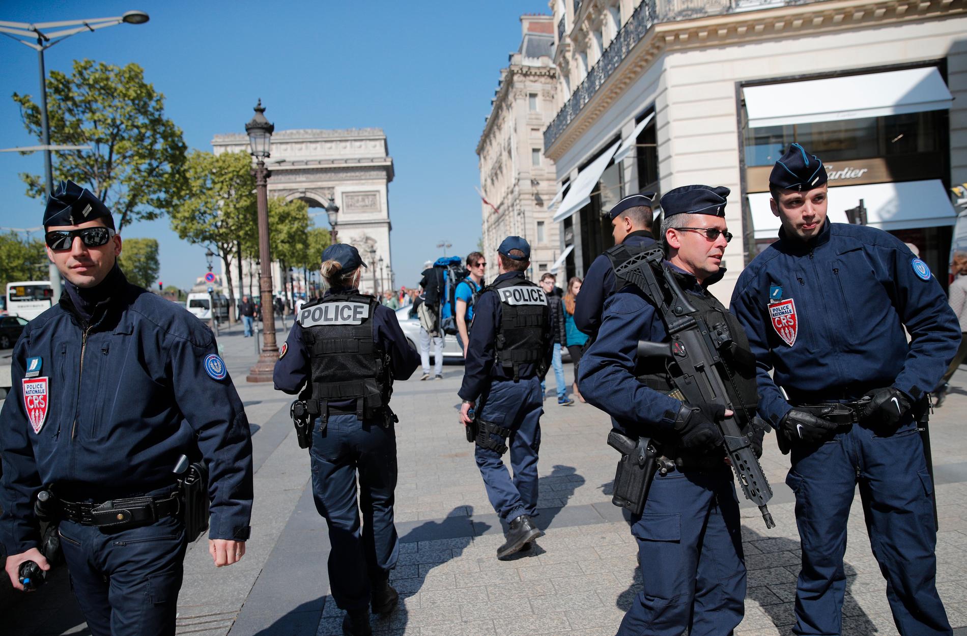 POLITIOPPBUD: Politiet var markant til stede i paradegaten Champs-Élysées fredag, dagen etter terrorangrepet. Det ble panikk i den travle gaten da en 39 år gammel mann begynte å skyte mot politiet. 