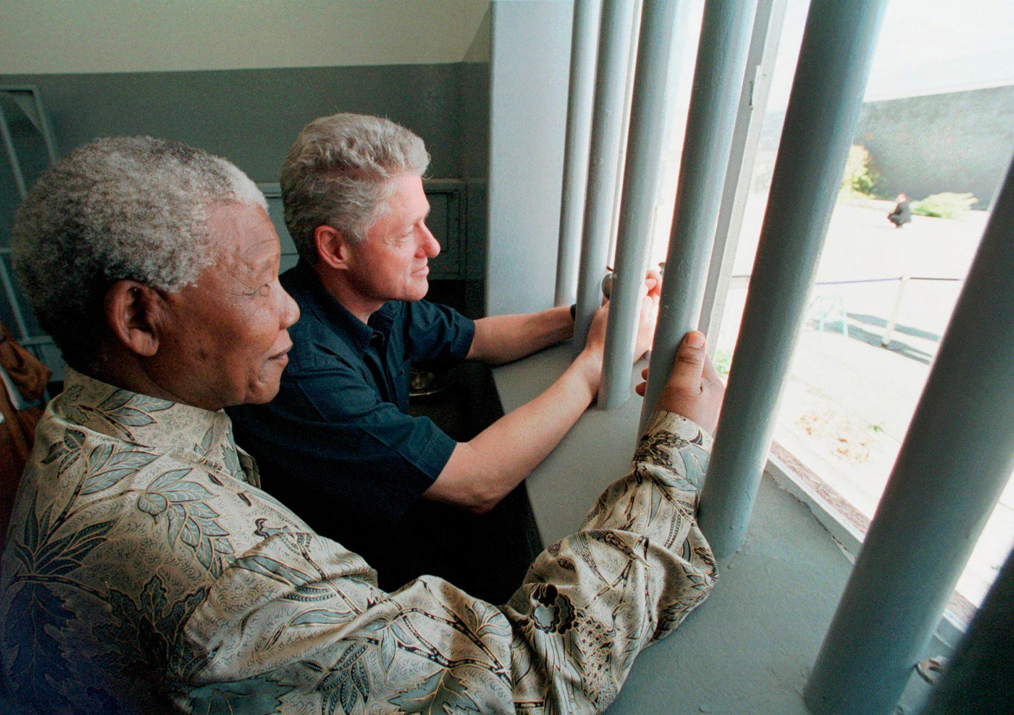Nelson Mandela viser tidligere president Bill Clinton sitt cellevindu på Robben Island. Her satt Mandela i 27 år. 