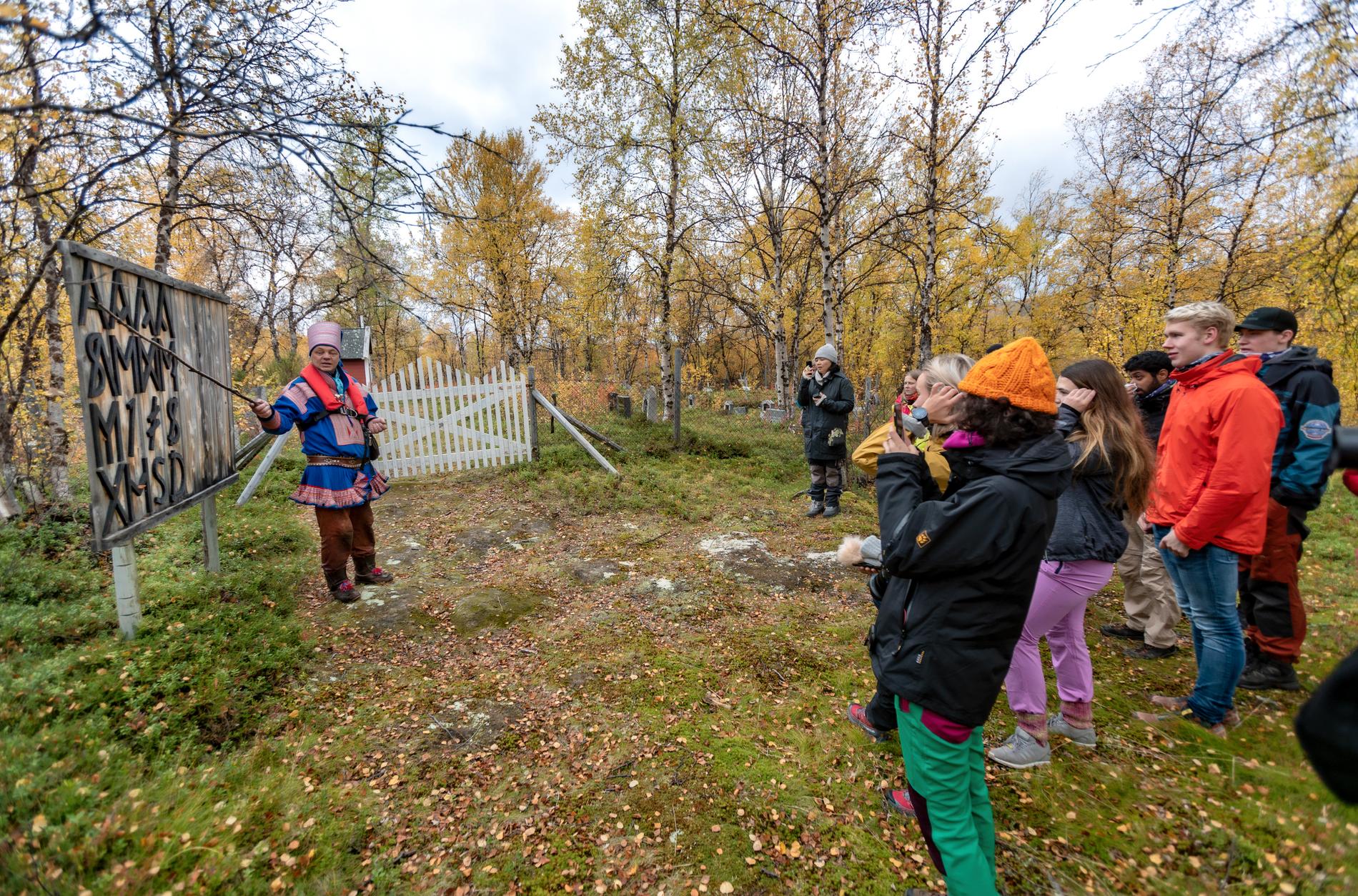 Er du med på tur, krever Johan P. Eira engasjement. Reiselivsstudentene får i oppgave å lære samiske bokstaver, før de går inn på kirkegården.