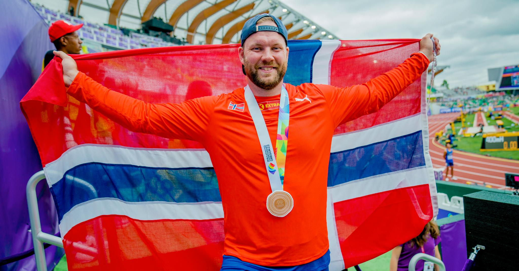 Eivind Henriksen var en lykkelig mann på vei ut av VM-arenaen Hayward Field med bronsemedalje rundt halsen og det norske flagget drapert rundt kroppen. 