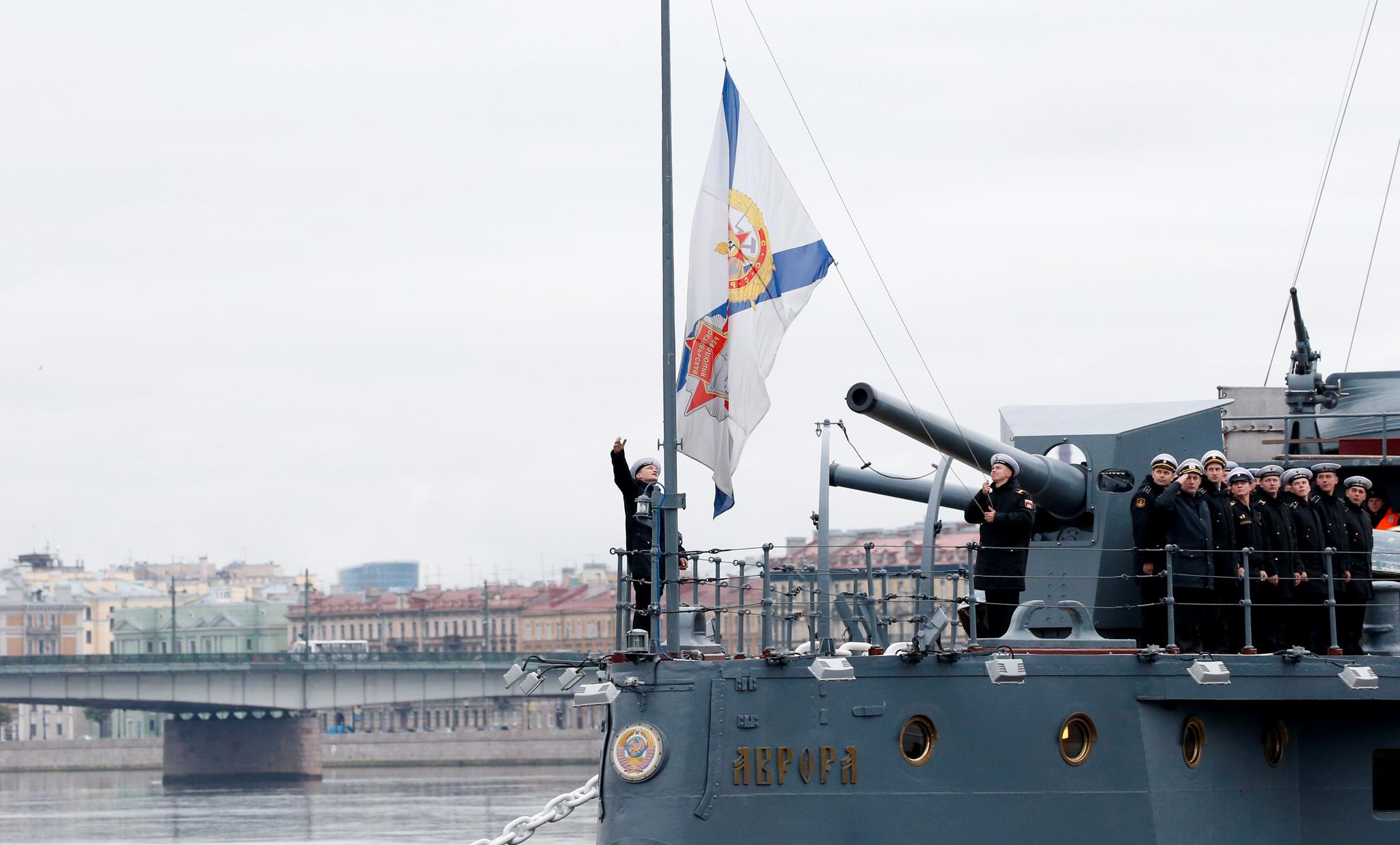 Russiske matroser hever flagget på krysseren Aurora i St. Petersburg. Aurora avfyrte skudd da revolusjonen startet for 100 år siden, men er i dag museum.