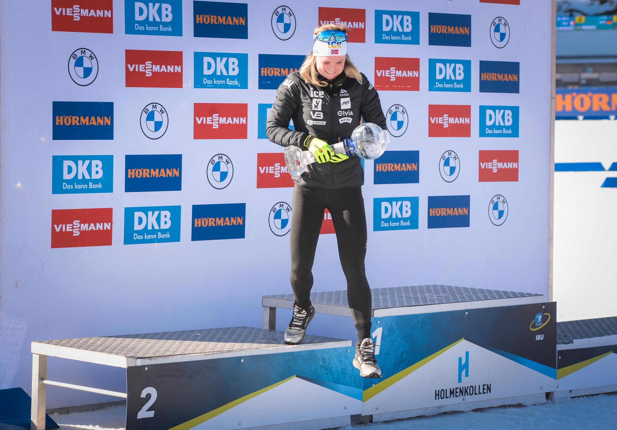 BEST I VERDEN: Marte Olsbu Røiseland på vei ned fra podiet i Holmenkollen etter å ha mottatt det store trofeet for sammenlagtseieren i verdenscupen.