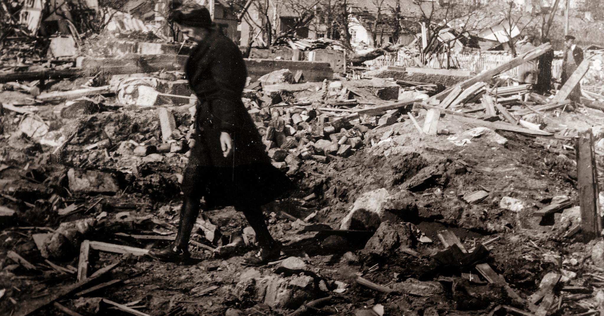  En kvinne leter desperat i ruinene av boliger på Vallø etter bombeinfernoet. 53 sivile ble drept da over 30 bolighus ble fullstendig jevnet med jorden. 