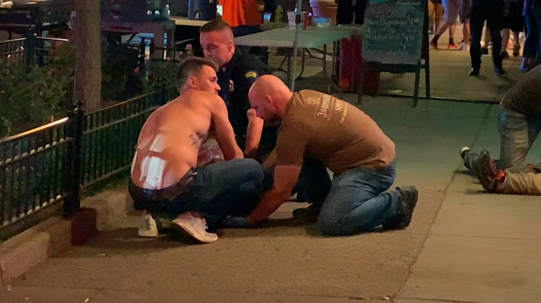 Masseskytingen foregikk i et utelivsområde i Dayton rett før stengetid natt til søndag. Her får et av ofrene hjelp av en ambulansesykepleier og frivillige på et fortauet i Oregon-området i sentrum. 
