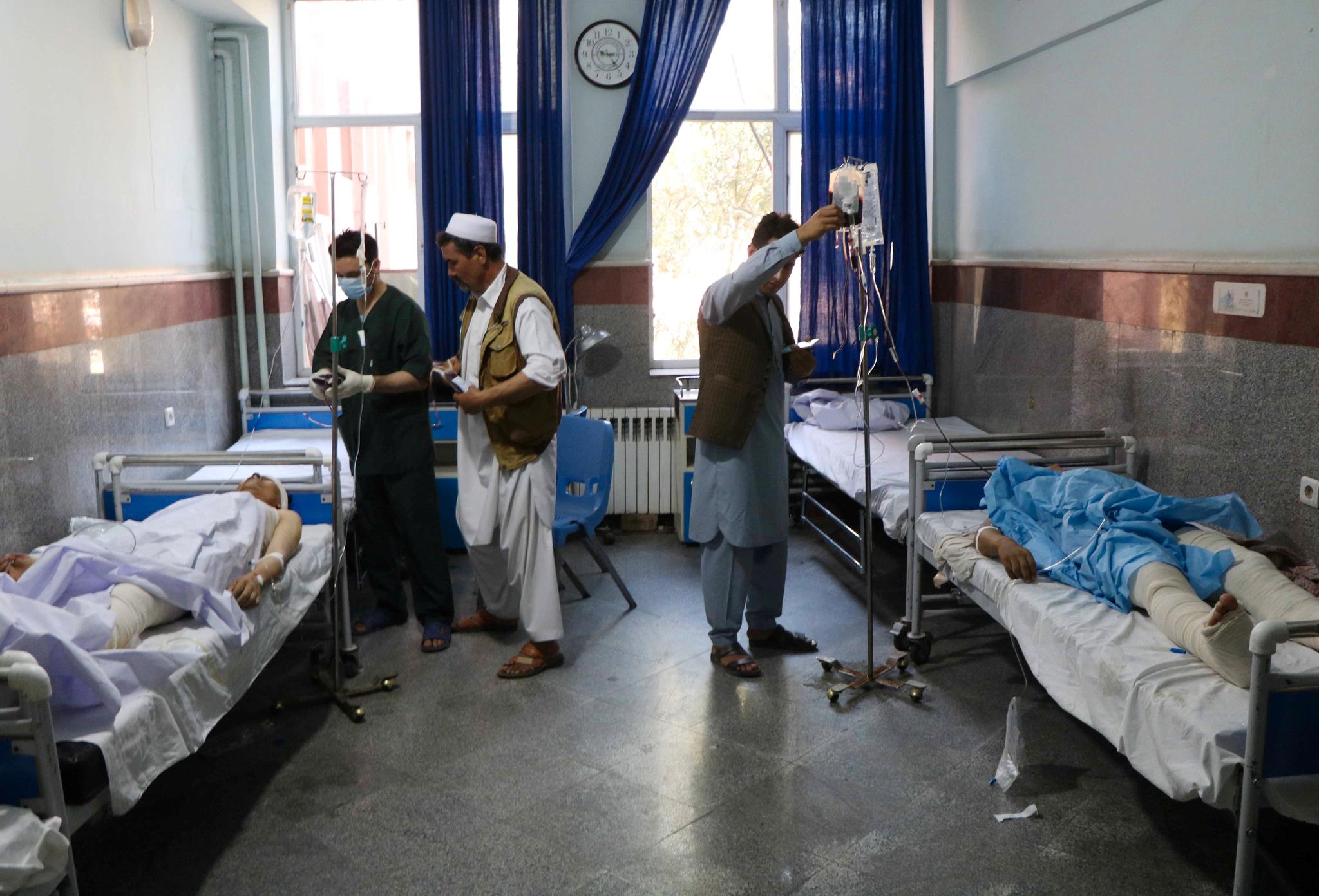 Afghanske menn får hjelp på et sykehus etter at en veibombe eksploderte ved en buss de satt i onsdag 31. juli. Minst 34 mennesker mistet livet.