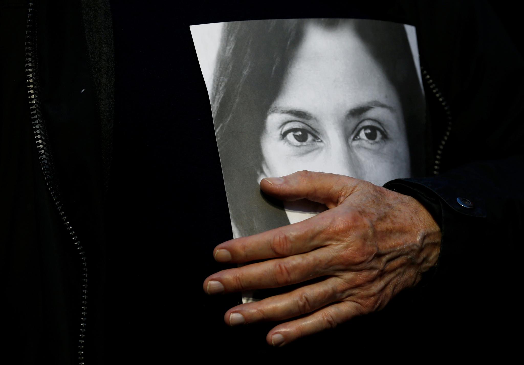 Faren til den avdøde journalisten Daphne Caruana Galizia holder et portrett av datteren under en demonstrasjon i Malta 1. desember.