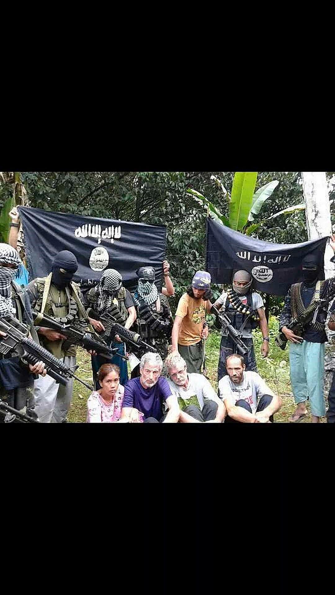 Dette bildet er hentet fra videoen som ble lagt ut på internett tirsdag. Det viser gislene som som ble bortført på Filippinene i september. Helt t.h. nederst sitter nordmannen Kjartan Sekkingstad. 