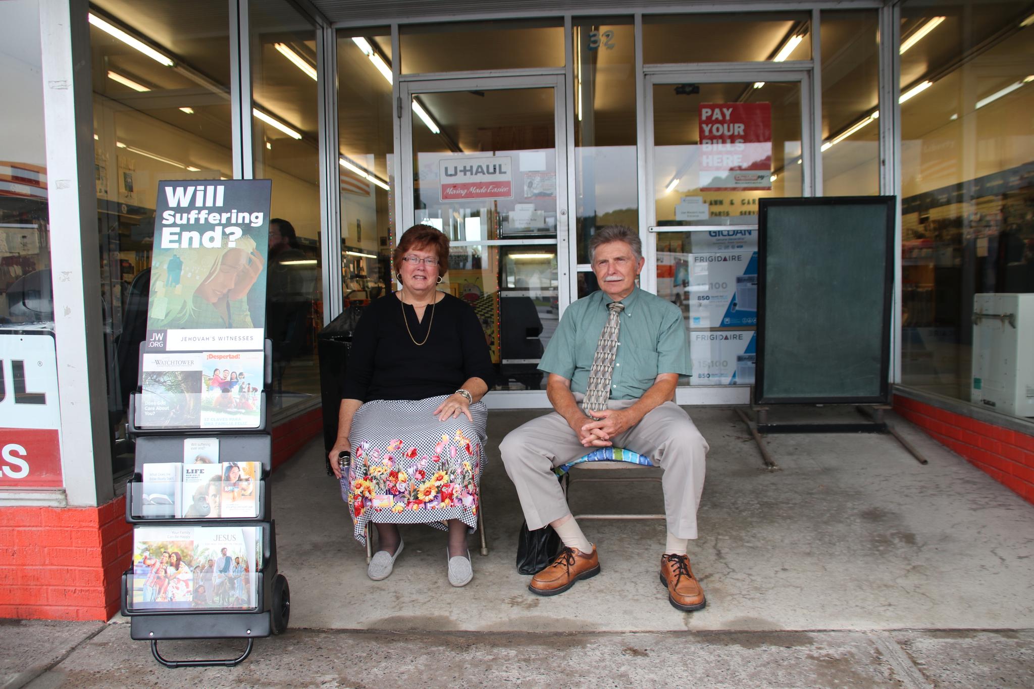 Ron og Sheryl Walsh fra Jehovas vitner sitter tålmodig utenfor en butikk i Rainelle og venter på folk de kan frelse. 
