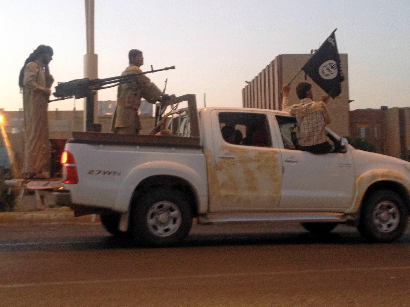 IS-krigere kjører rundt med sitt etter hvert velkjente svarte flagg med påskriften «Det er ingen gud utenom Gud, og Muhammed er hans profet».