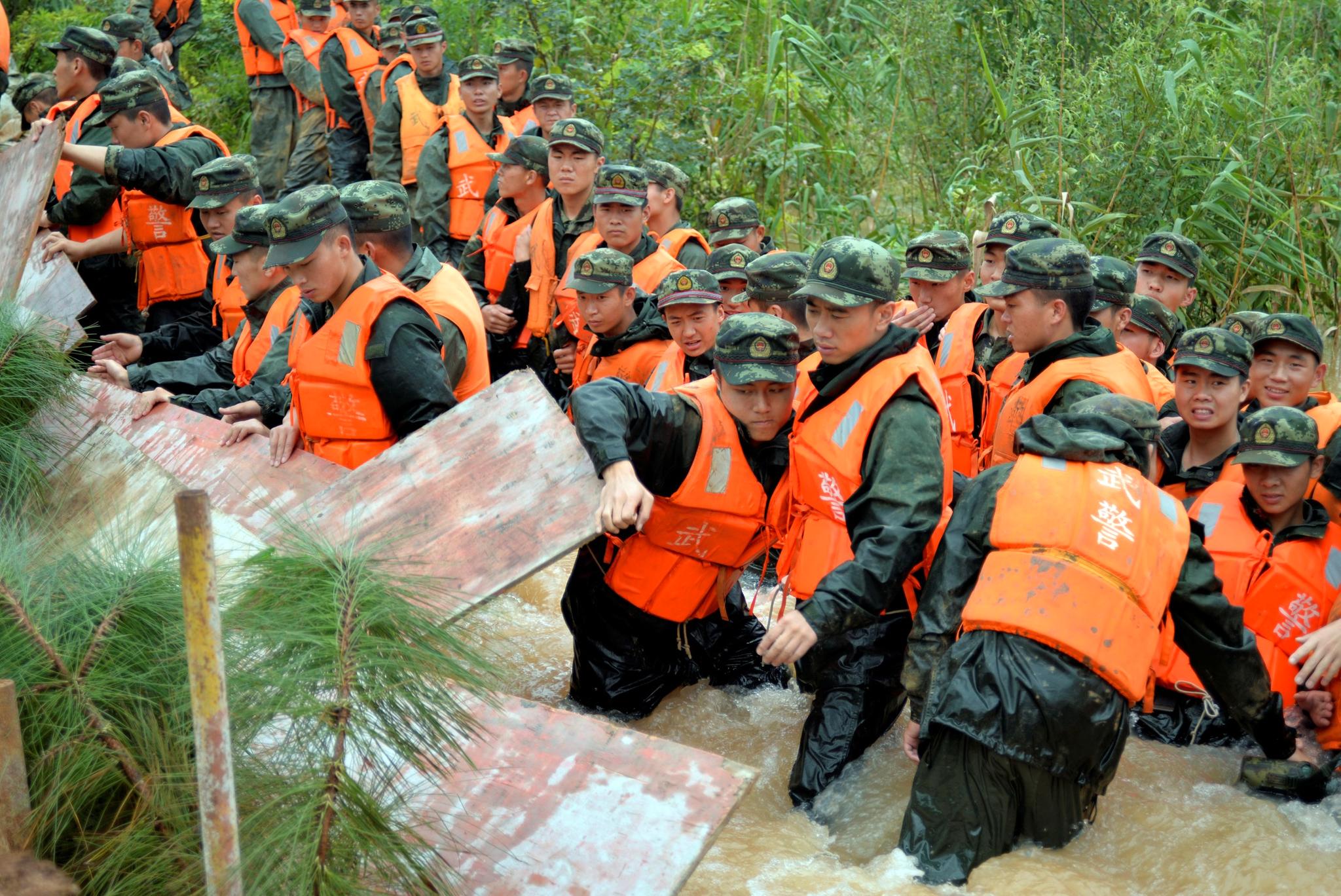 Politifolk i arbeid for å  begrense skadene av oversvømmelser i Nanjing i Jiangsu.